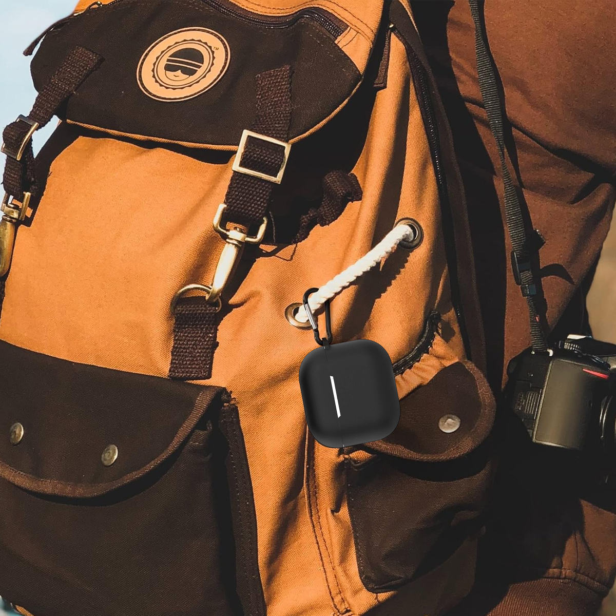 Ein schwarzes Etui für kabellose Kopfhörer hängt an einem Rucksack.