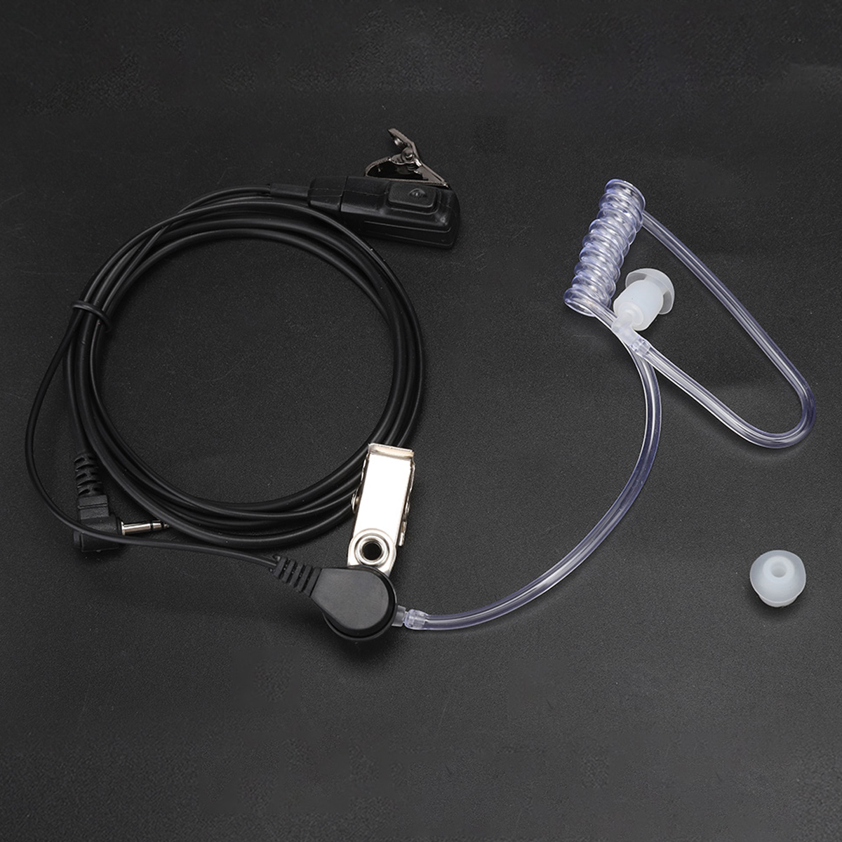 Ein schwarzes Headset mit einem Clip, einem Spiralschlauch und einem Ohrstöpsel.