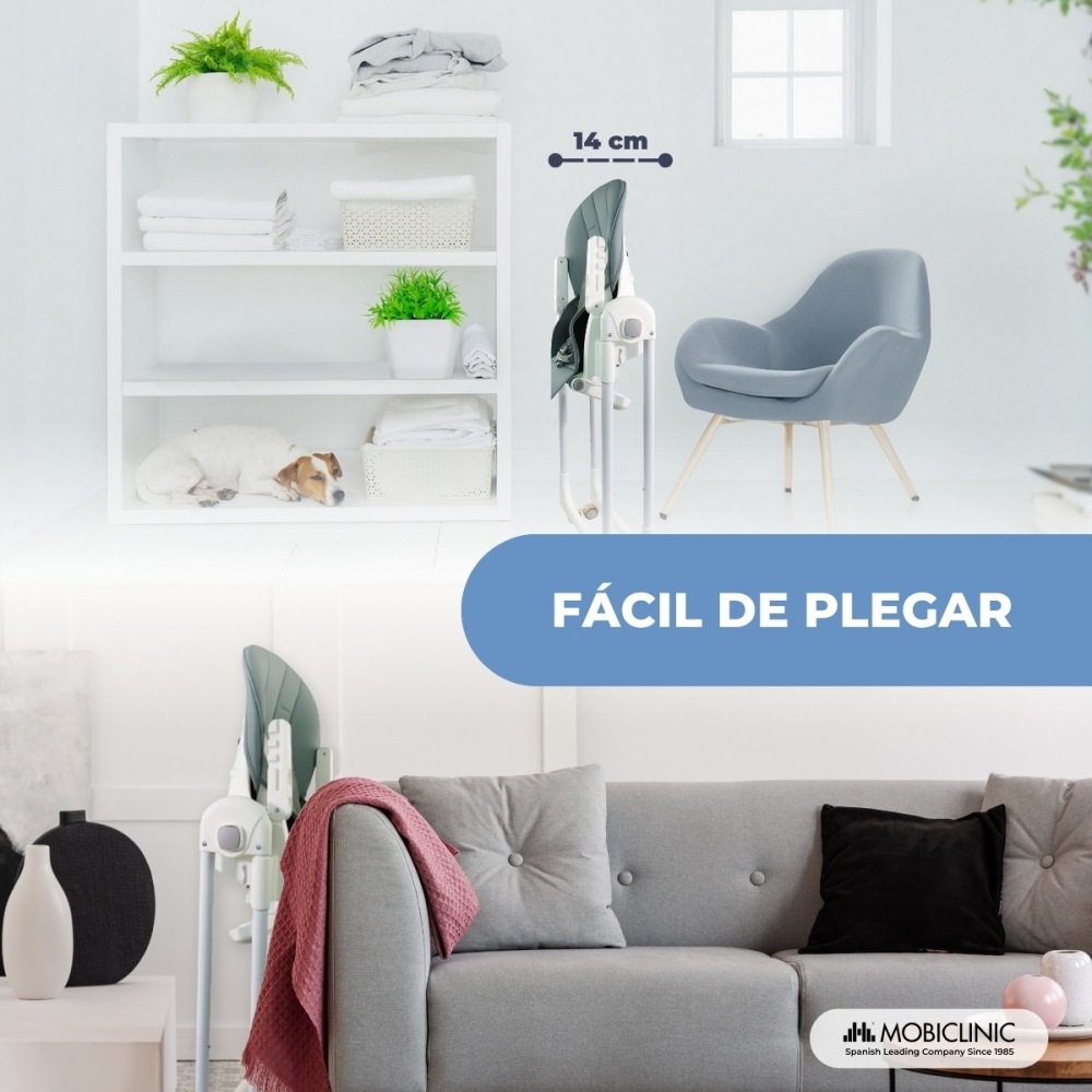 Una trona plegable junto a un sillón gris en una habitación luminosa.
