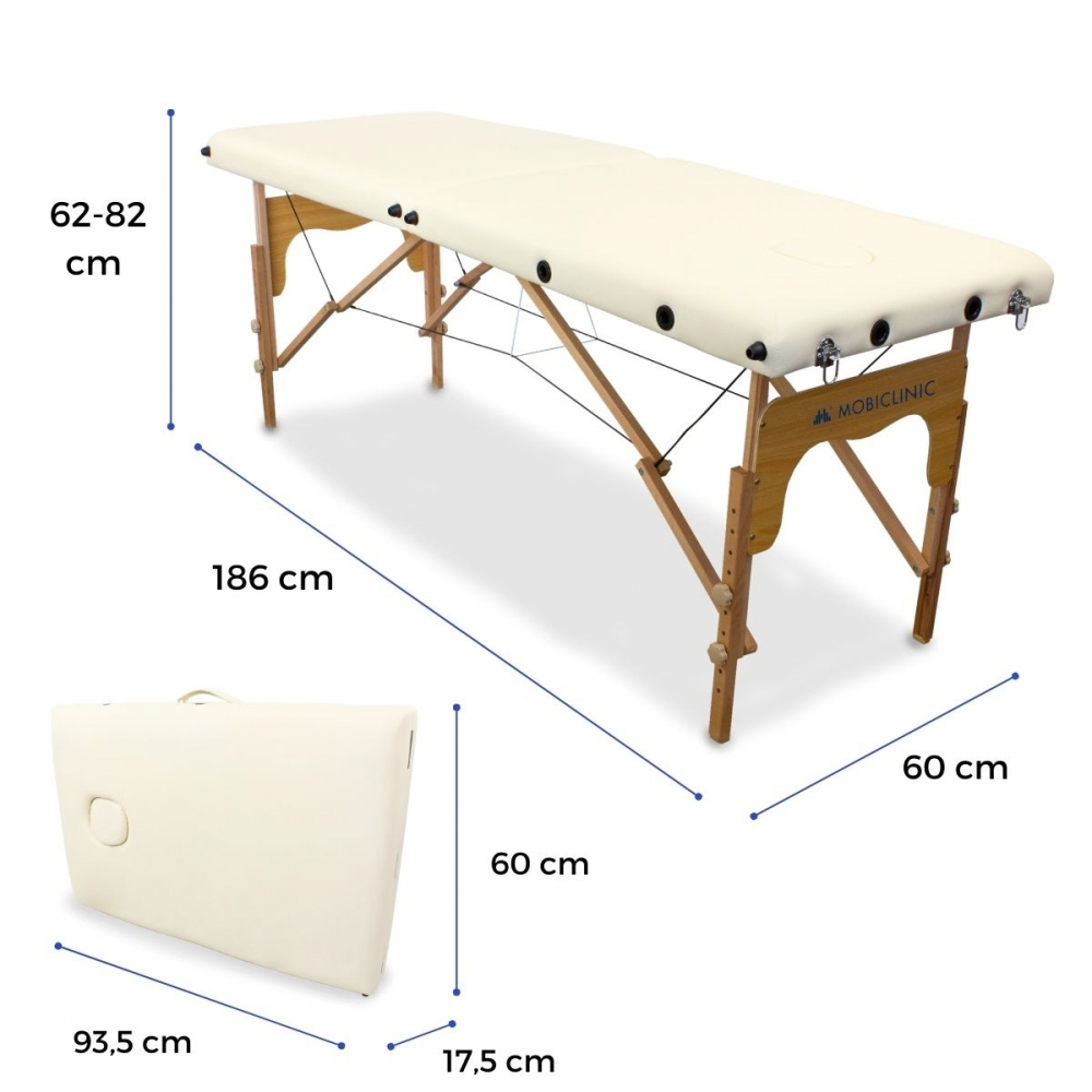 Mesa de masaje abierta y plegada de madera clara con tapicería crema. Dimensiones mostradas.