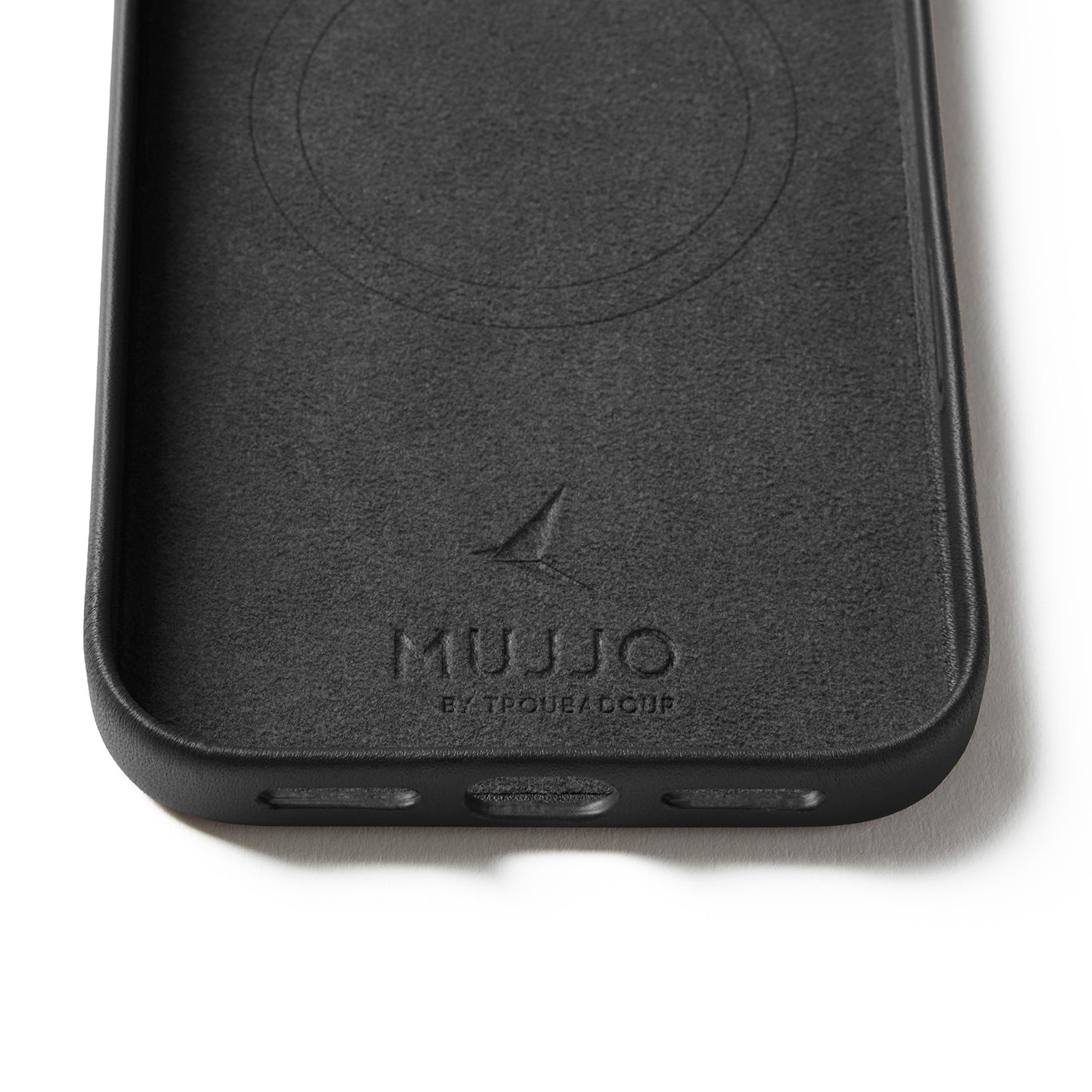 Wnętrze czarnego etui na telefon z wytłoczonym logo Mujjo i okrągłym wzorem magnesu.