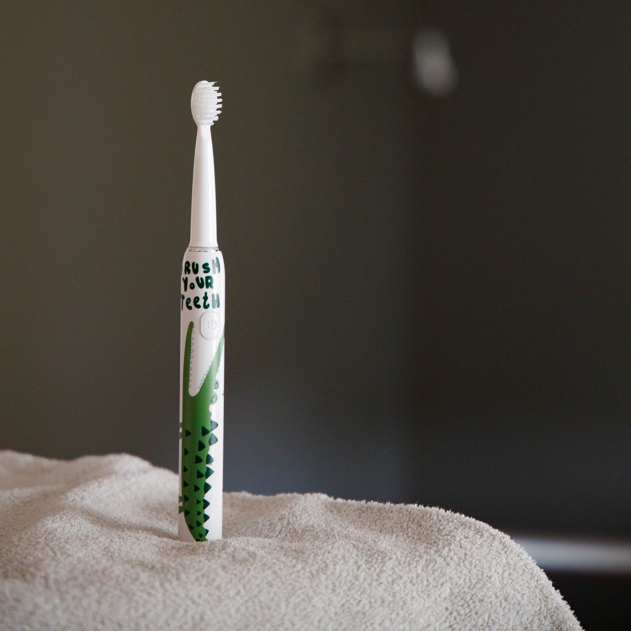 Uno spazzolino bianco con design a coccodrillo e testo "RUSH YOUR TEETH".