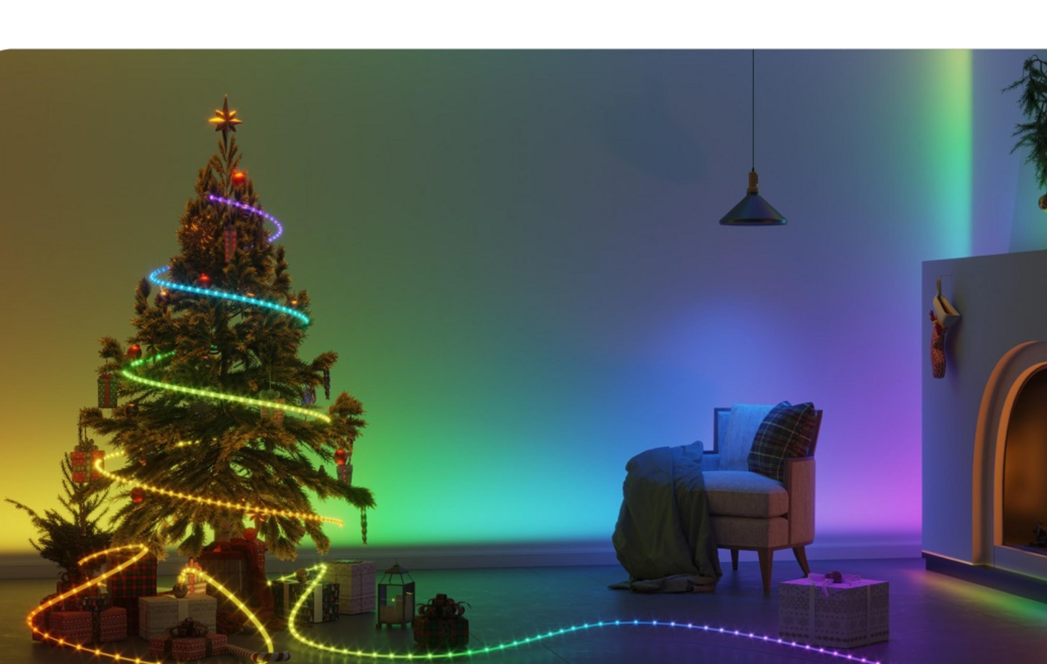 Işıklı Noel ağacı, hediyeler ve odada bir koltuk.