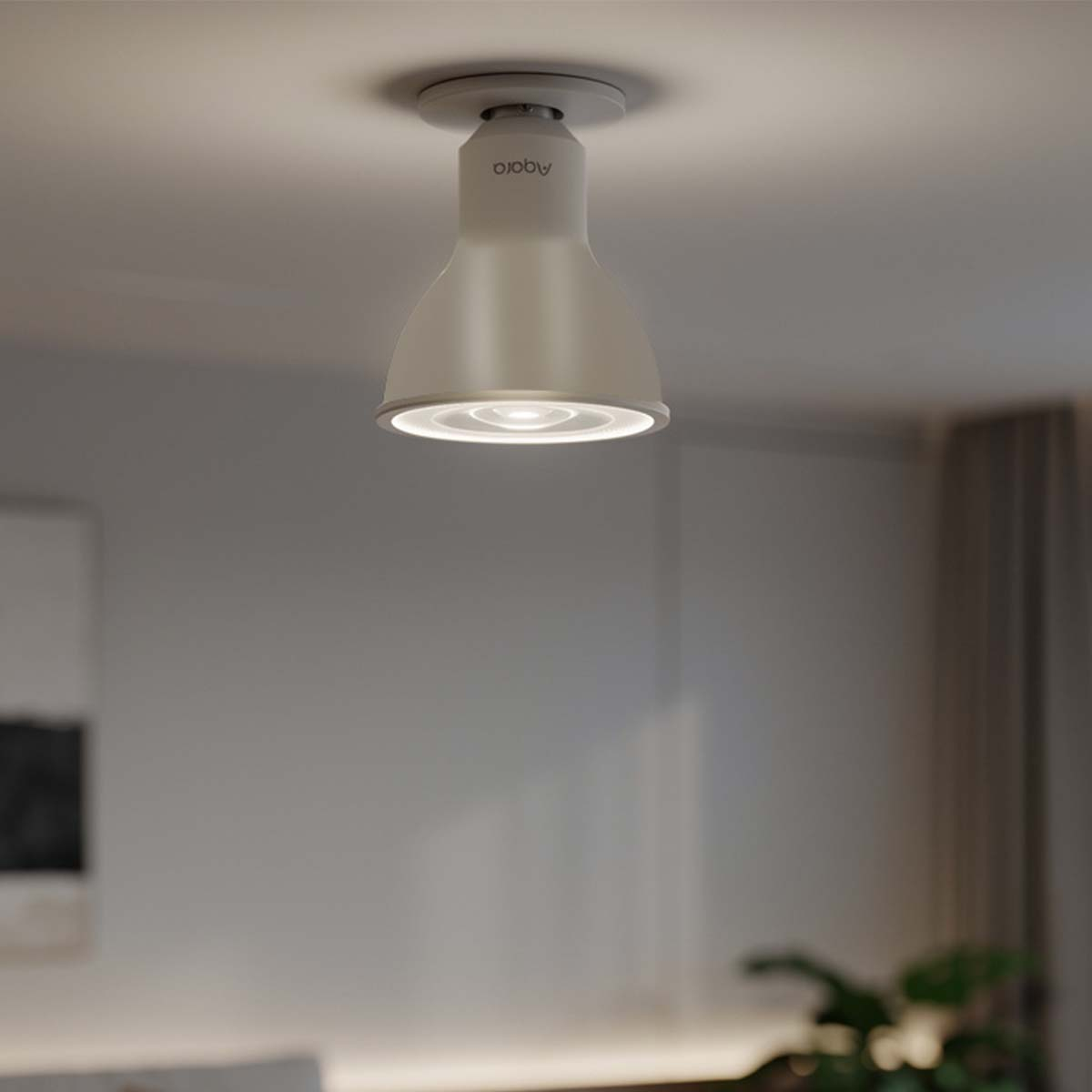 Una lampada da soffitto bianca con logo 'aqara' illuminata. Lo sfondo è sfocato.