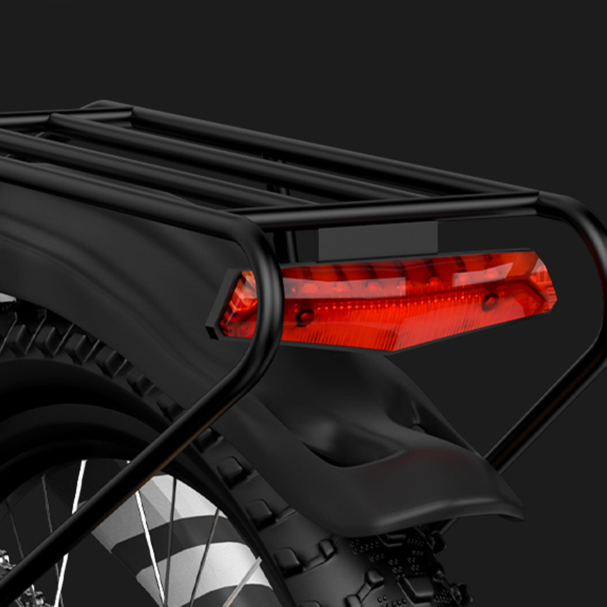 Tylne światło i bagażnik czarnego roweru na czarnym tle.