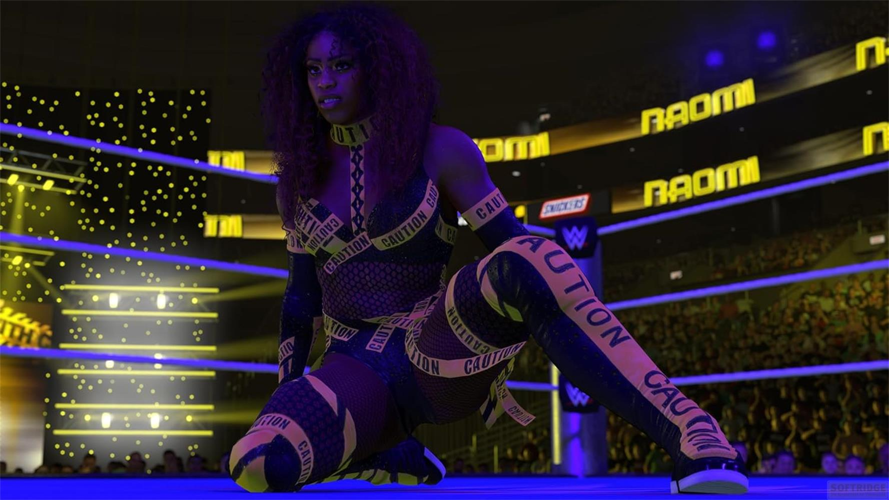 Wrestlerin in einem Ring, trägt Kleidung mit 'CAUTION'-Aufdruck. Gelbe Lichter.