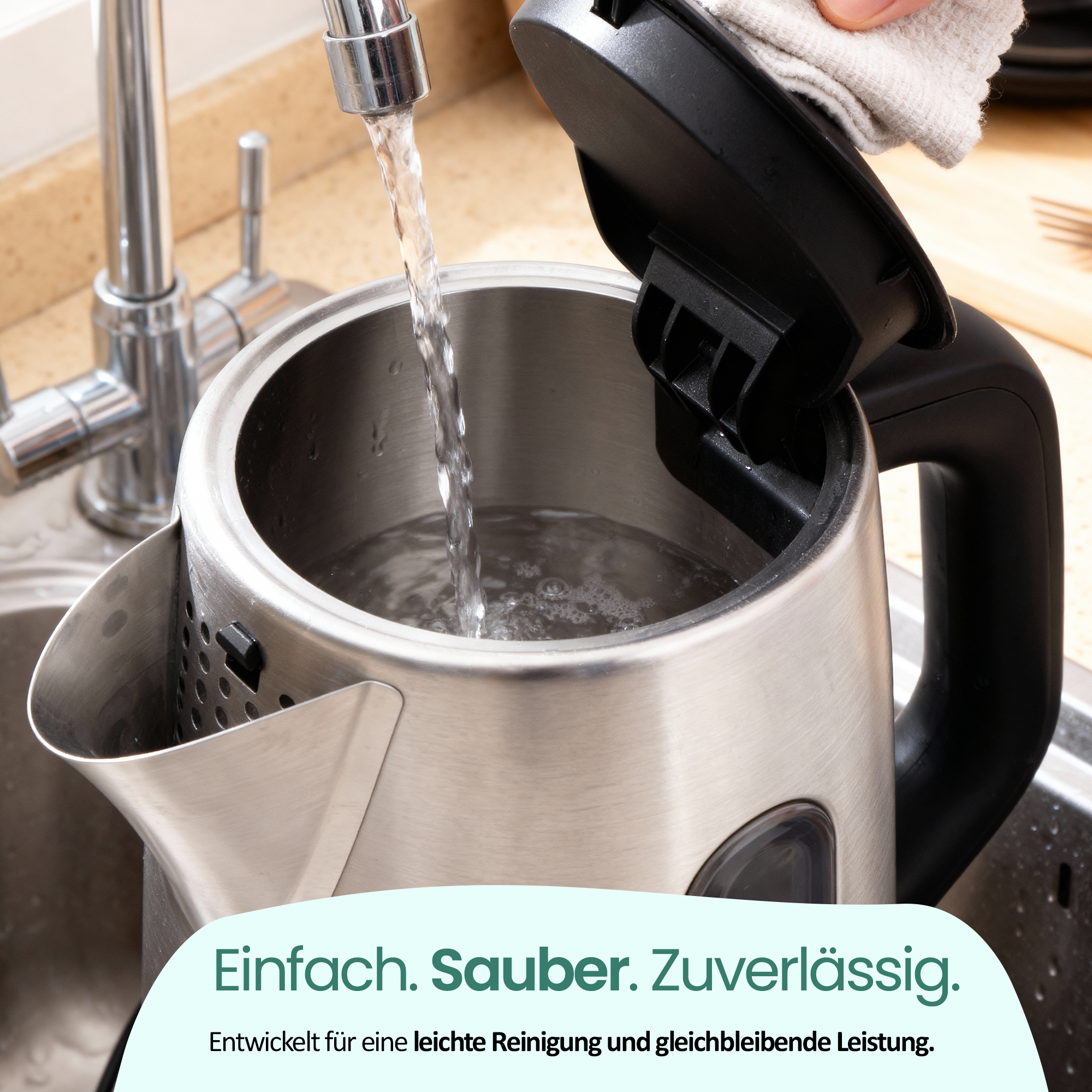 Wasser fließt in einen silbernen Wasserkocher. Eine Hand wischt den Deckel ab.