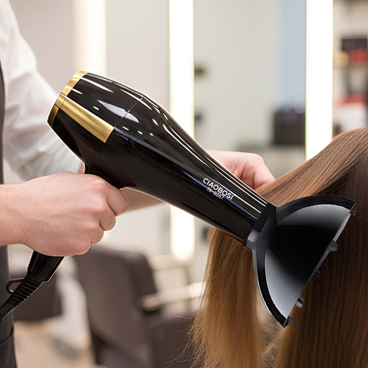Ein schwarzer Haartrockner mit goldenen Akzenten trocknet braunes Haar im Salon.
