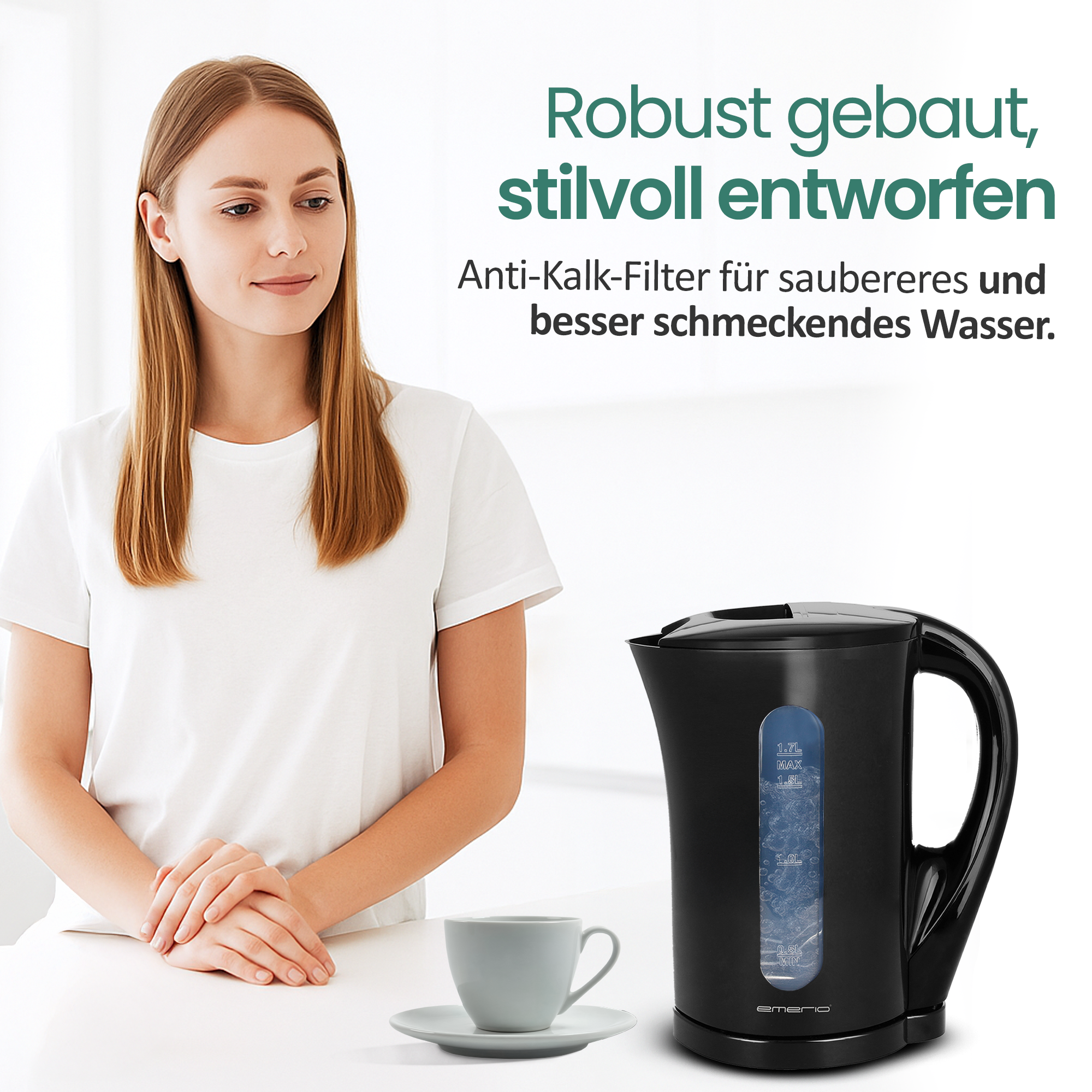 Eine Frau sitzt neben einem schwarzen Wasserkocher und einer Tasse.