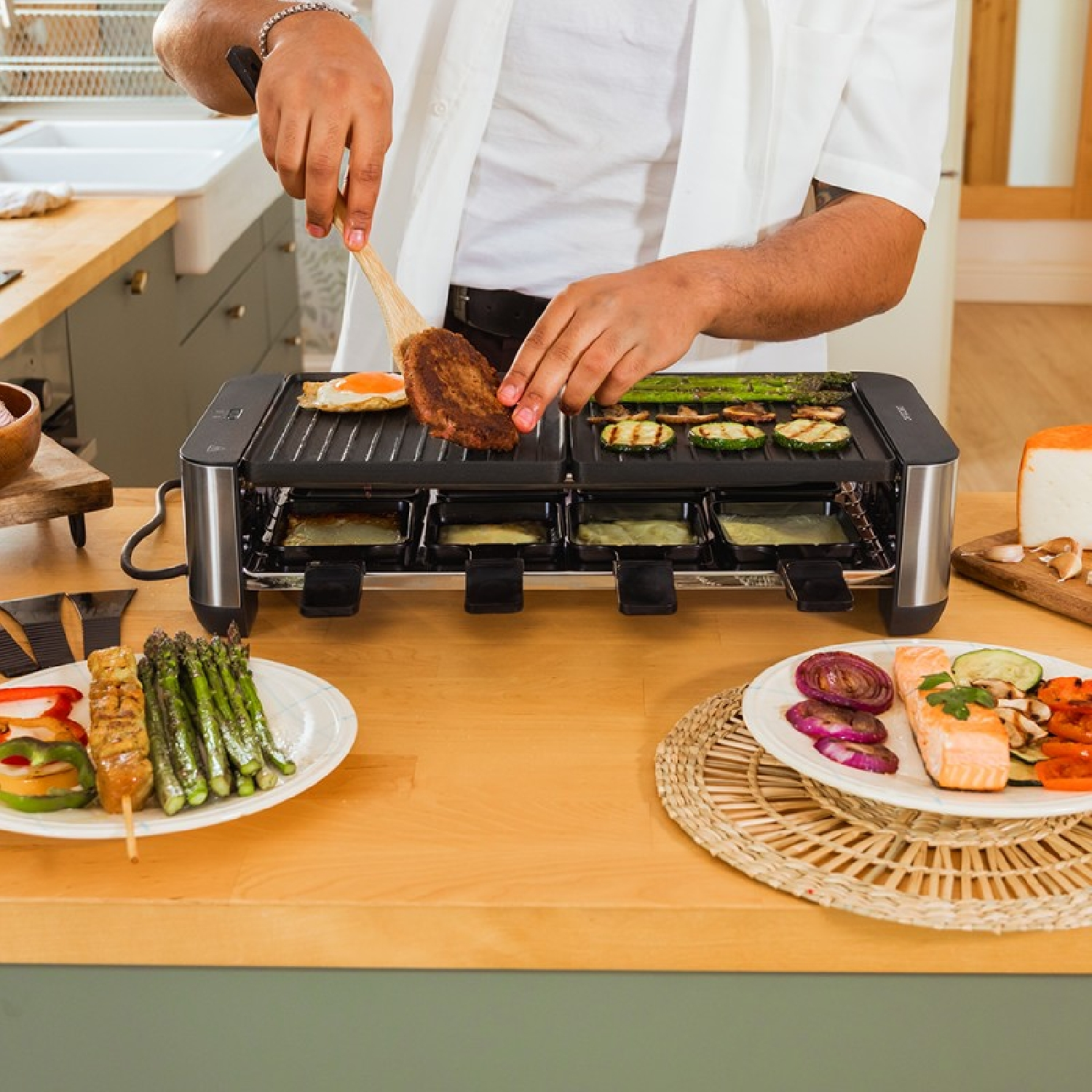 Osoba gotuje na grillu raclette z burgerem, jajkiem sadzonym i warzywami.