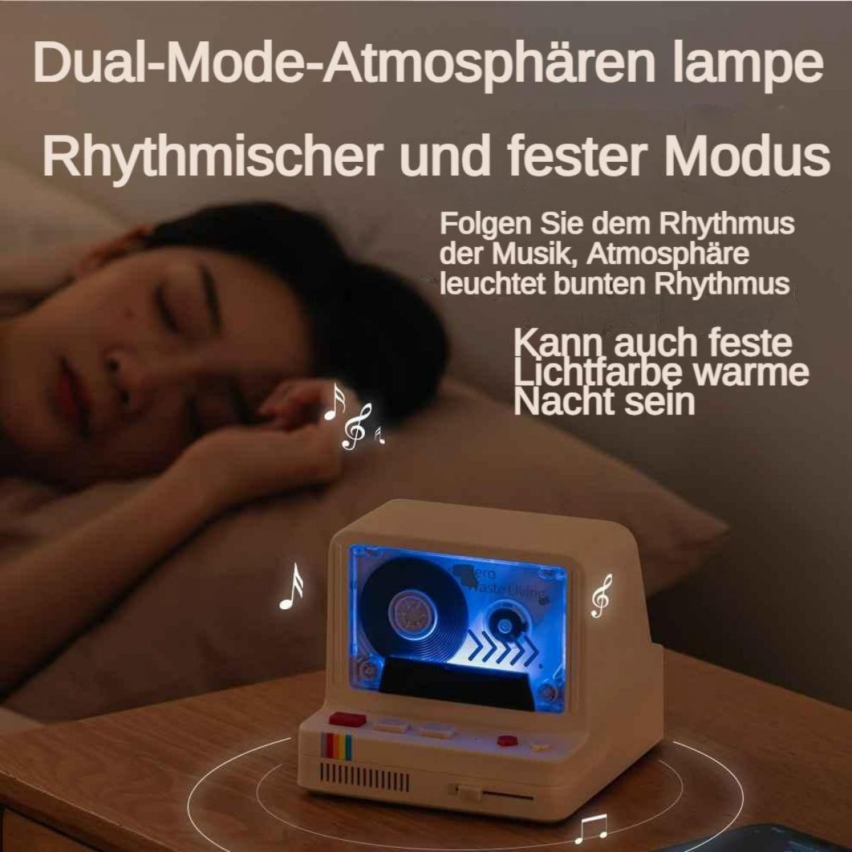 Eine Person schläft neben einer Lampe in Form einer Kassette, die blau leuchtet.