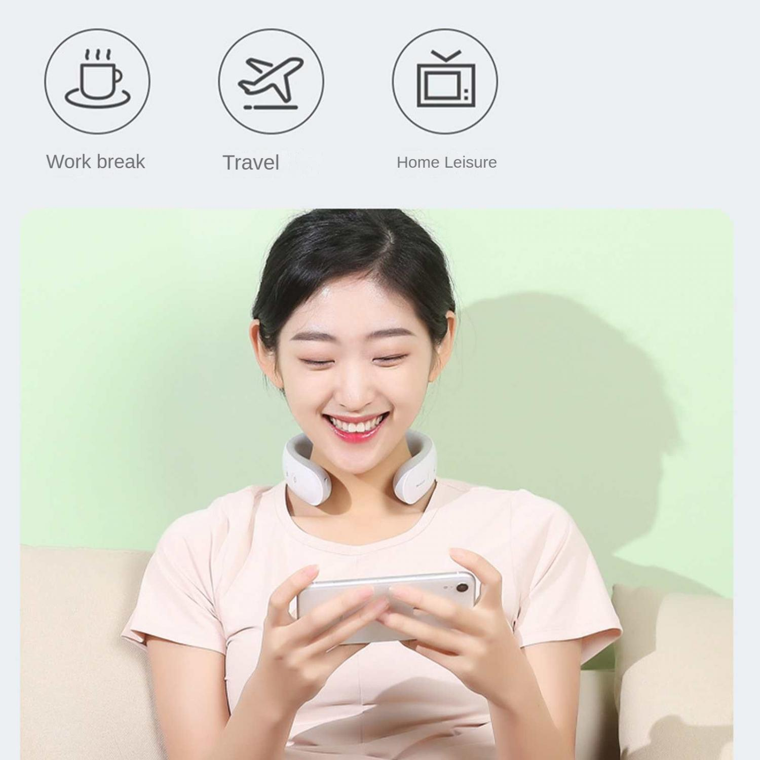 Eine lächelnde Frau mit einem Nackenmassagegerät nutzt ihr Handy.