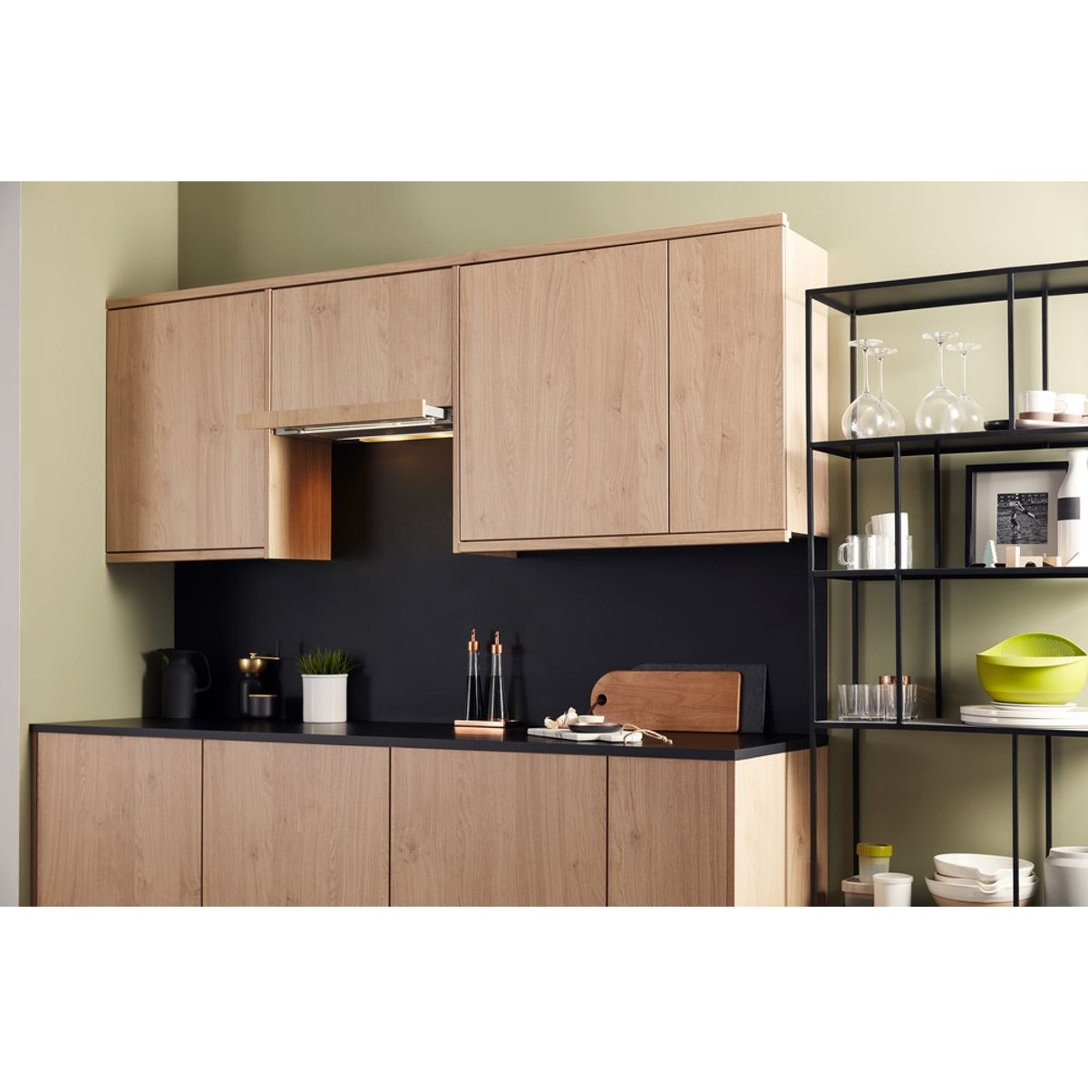 Cocina moderna con gabinetes de madera, encimera negra y estantería.