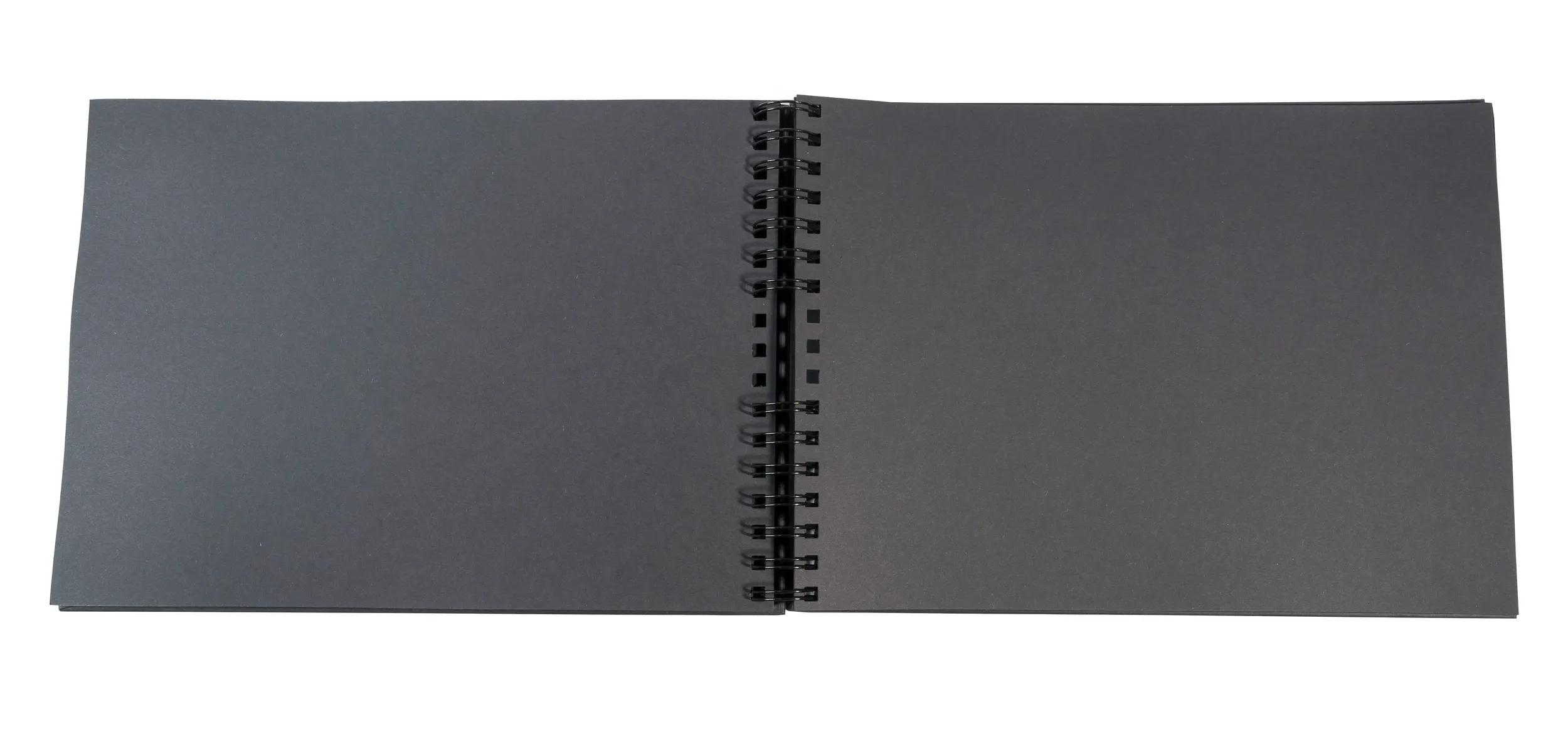 Un cuaderno abierto con páginas negras y encuadernación en espiral.