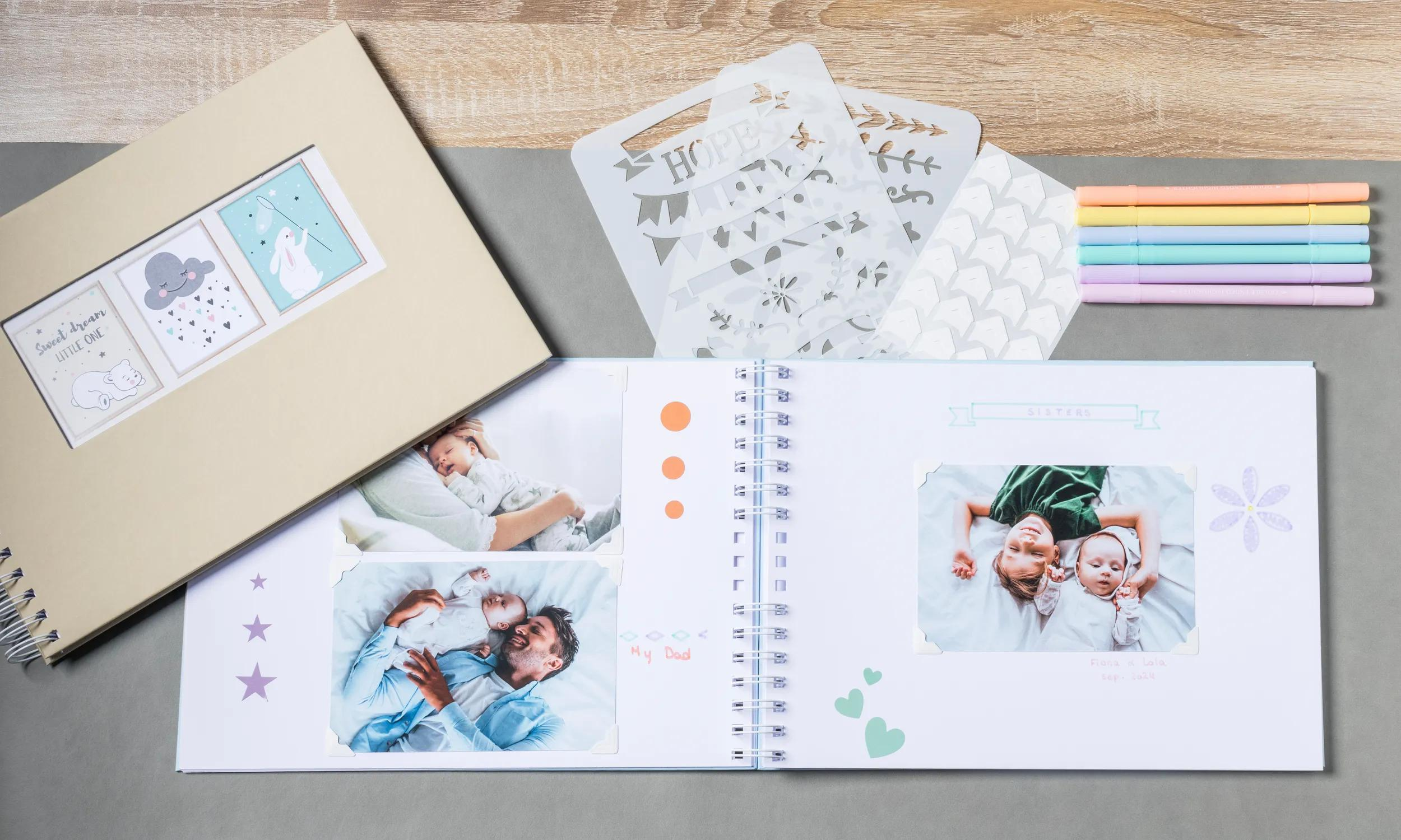 Un álbum de recortes abierto con fotos de bebés, plantillas y rotuladores.