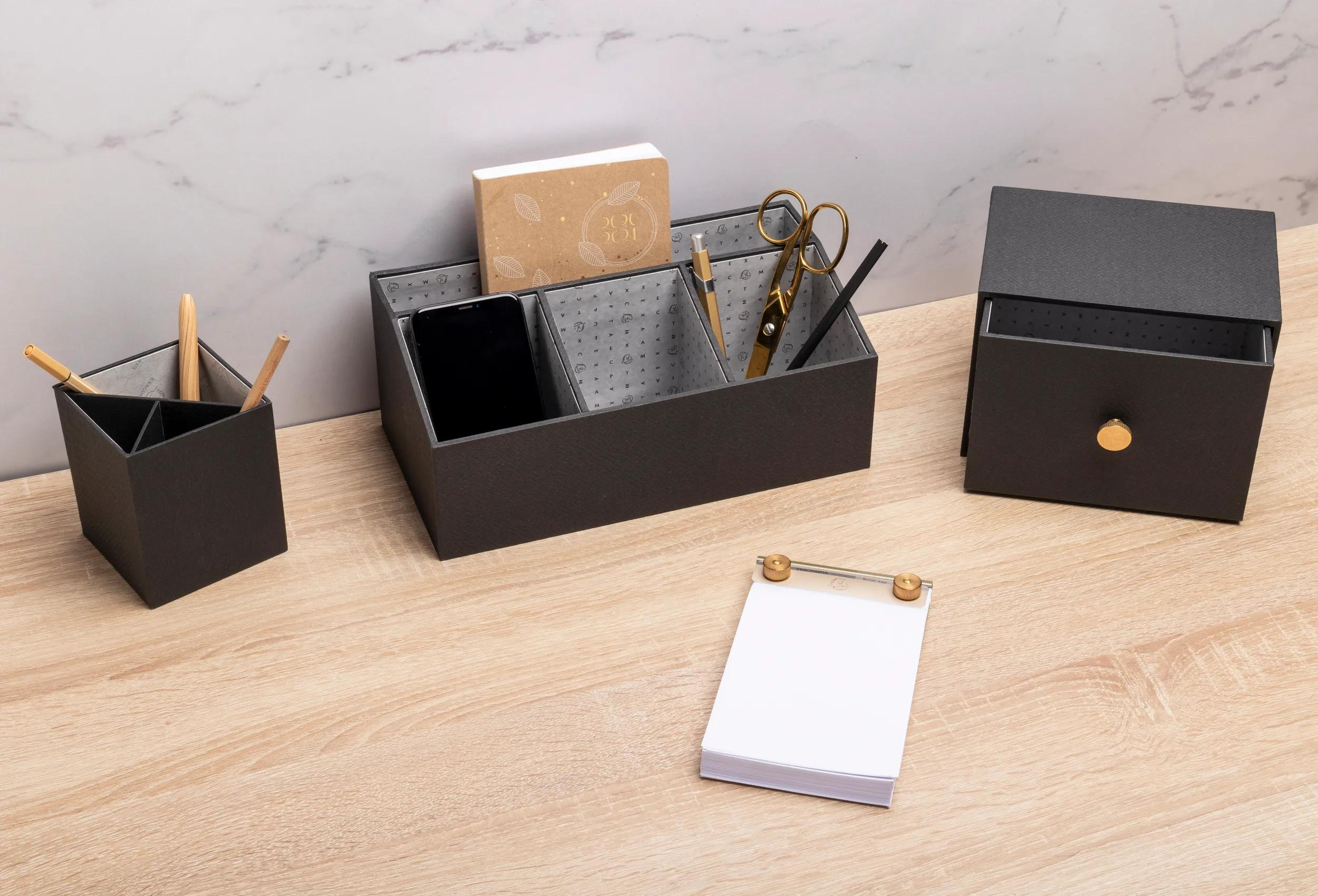 Organizador de escritorio con teléfono, libreta, bolígrafos, tijeras y cajón.