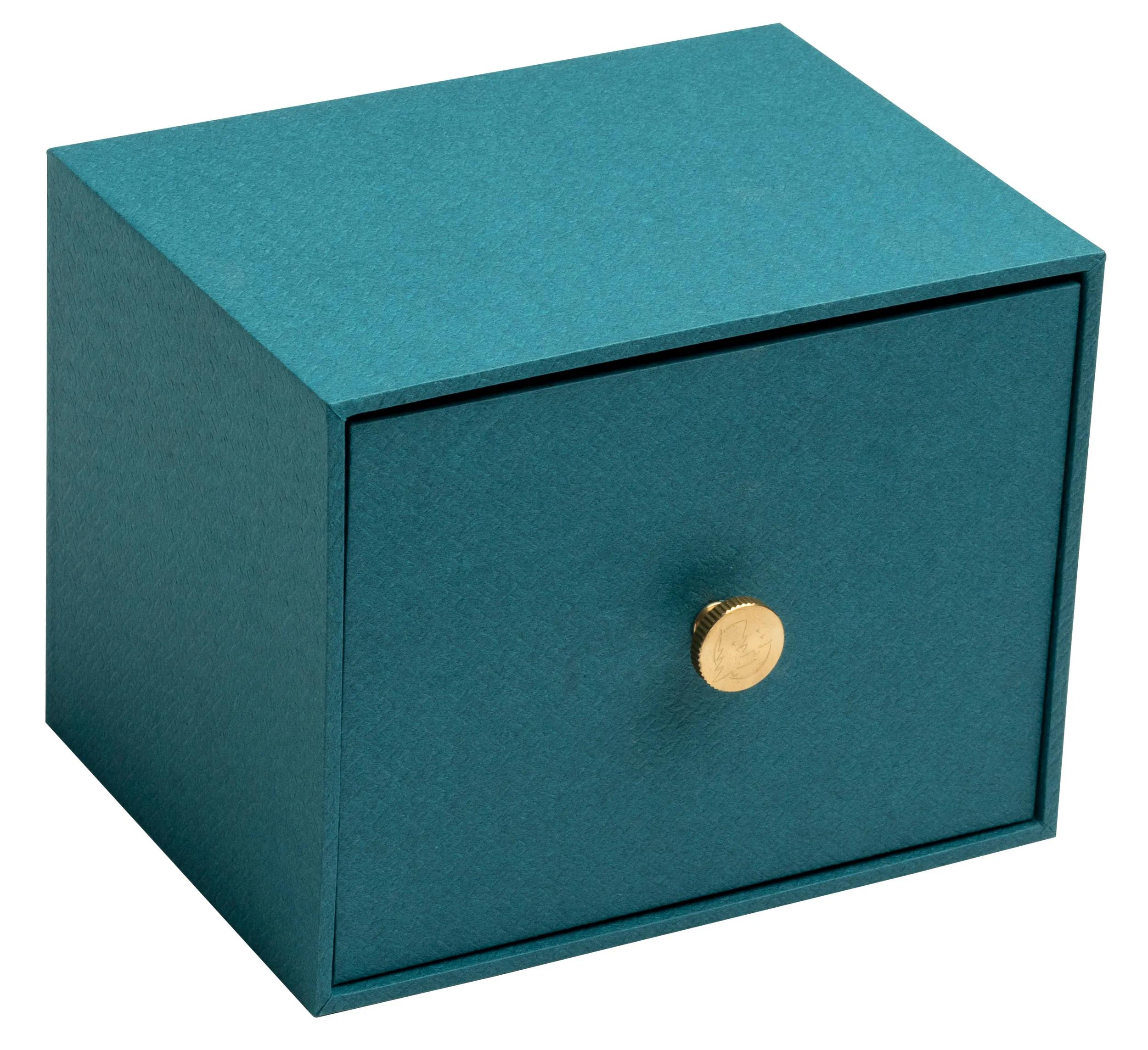 Una pequeña caja de almacenamiento de color verde azulado con un cajón y un pomo dorado.