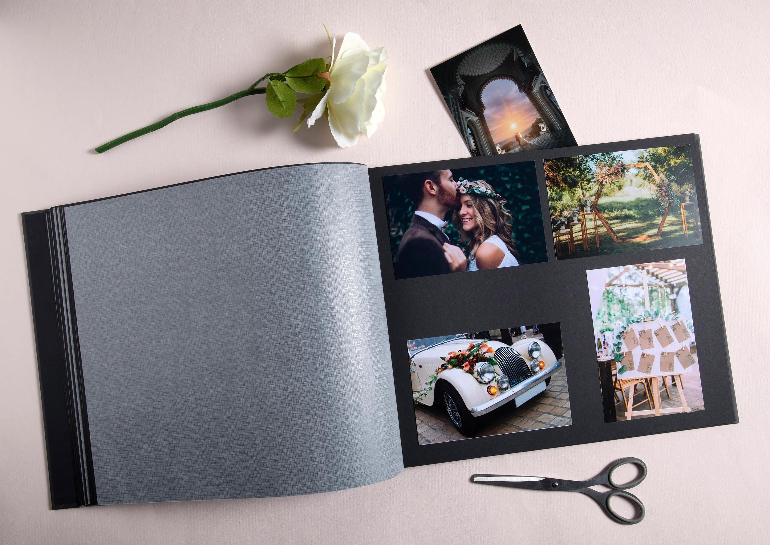 Un álbum de fotos abierto con fotos de bodas, una rosa blanca y tijeras.