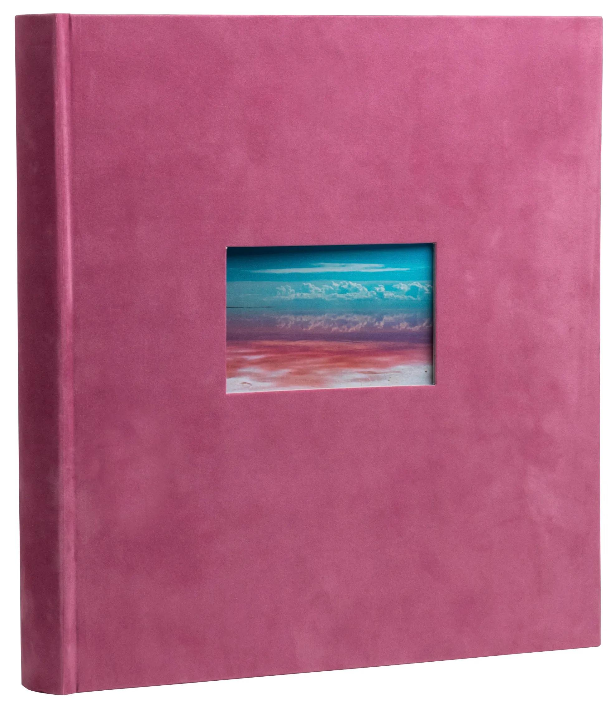 Un álbum rosa con un recorte que muestra un lago salado y nubes.