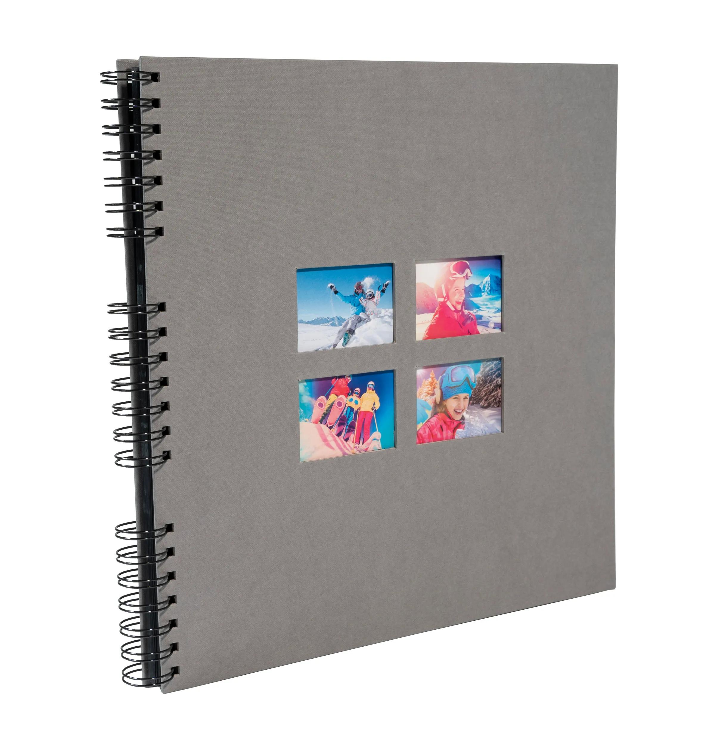 Álbum gris de espiral con cuatro fotos pequeñas de esquiadores en la nieve.