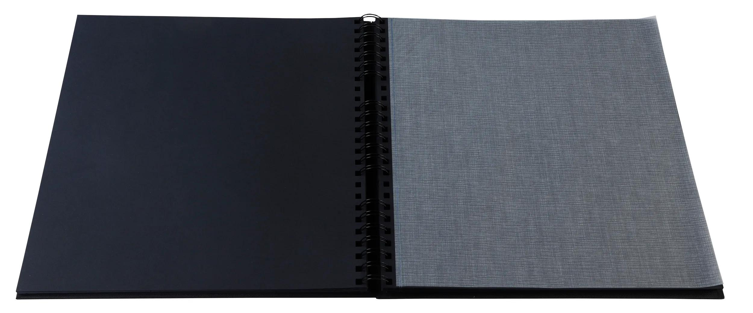 Un cuaderno abierto con página negra y gris, encuadernado en negro.