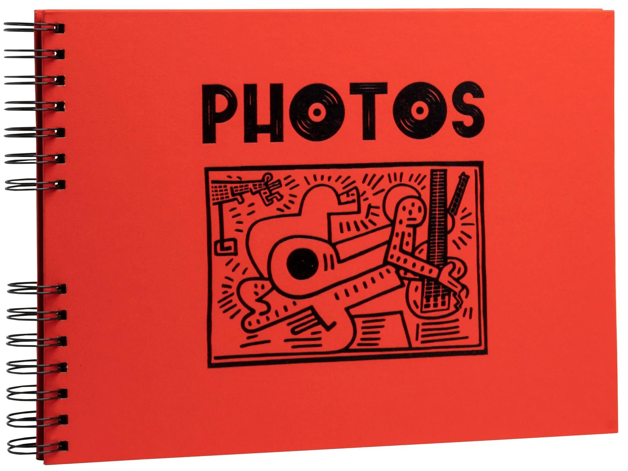Un cuaderno rojo con el texto "PHOTOS" y un dibujo negro de figuras.