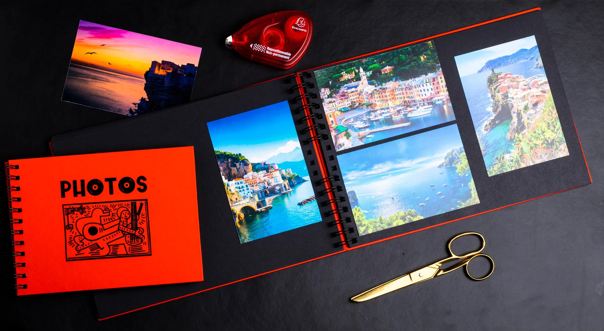 Un álbum de fotos con fotos de viajes, tijeras y cinta sobre fondo negro.