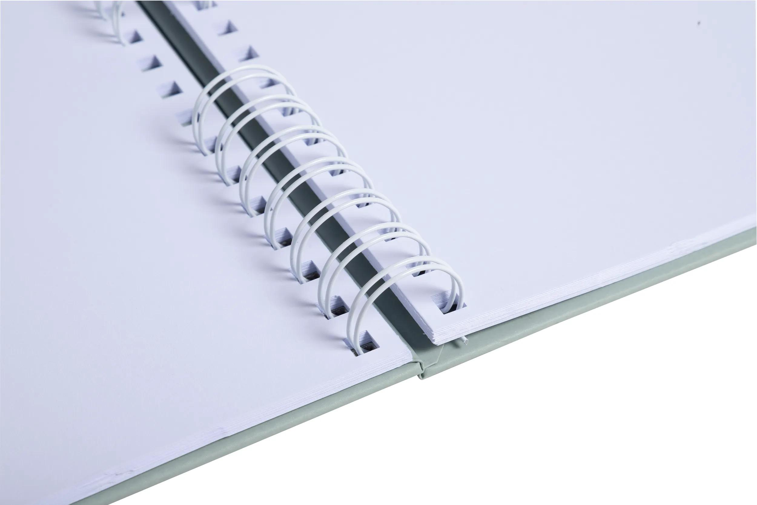 Un cuaderno abierto con páginas blancas y encuadernación de espiral plateada.