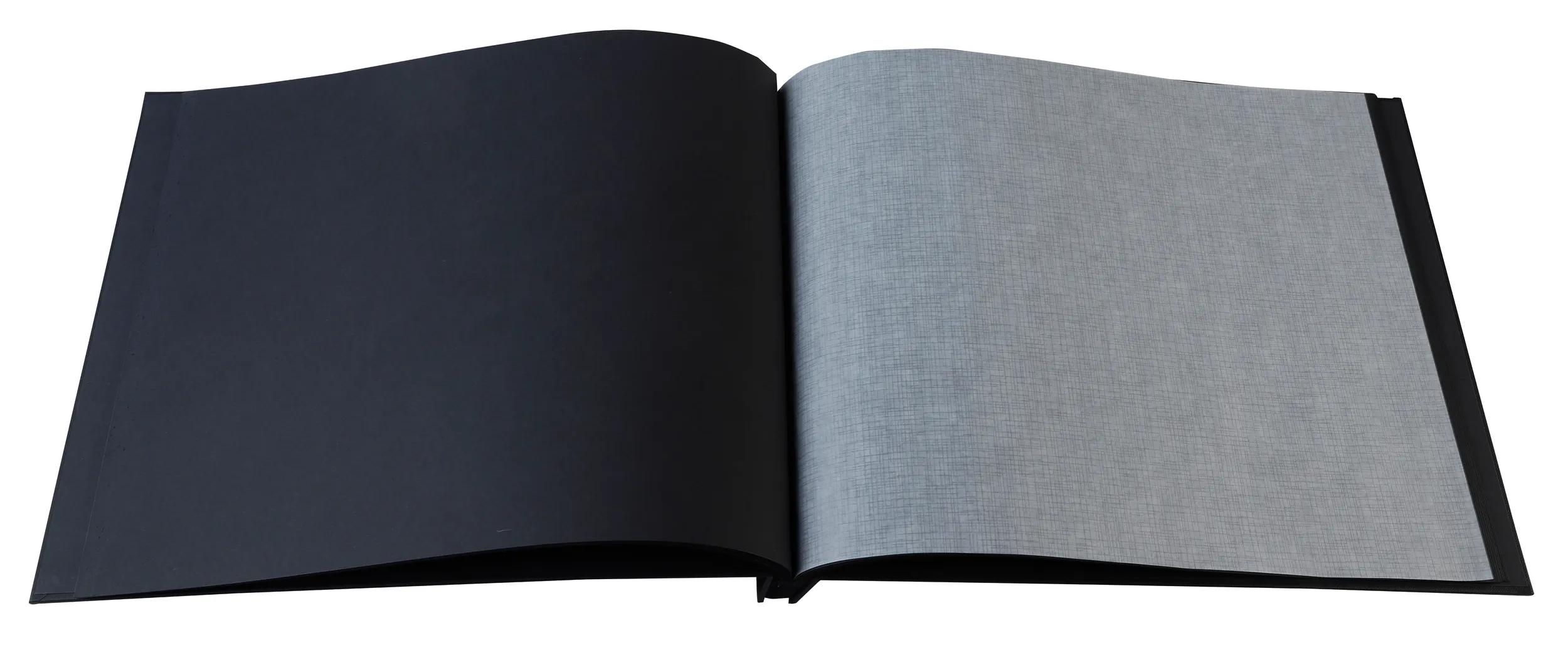 Un libro aperto con pagine nere e grigie su sfondo bianco.