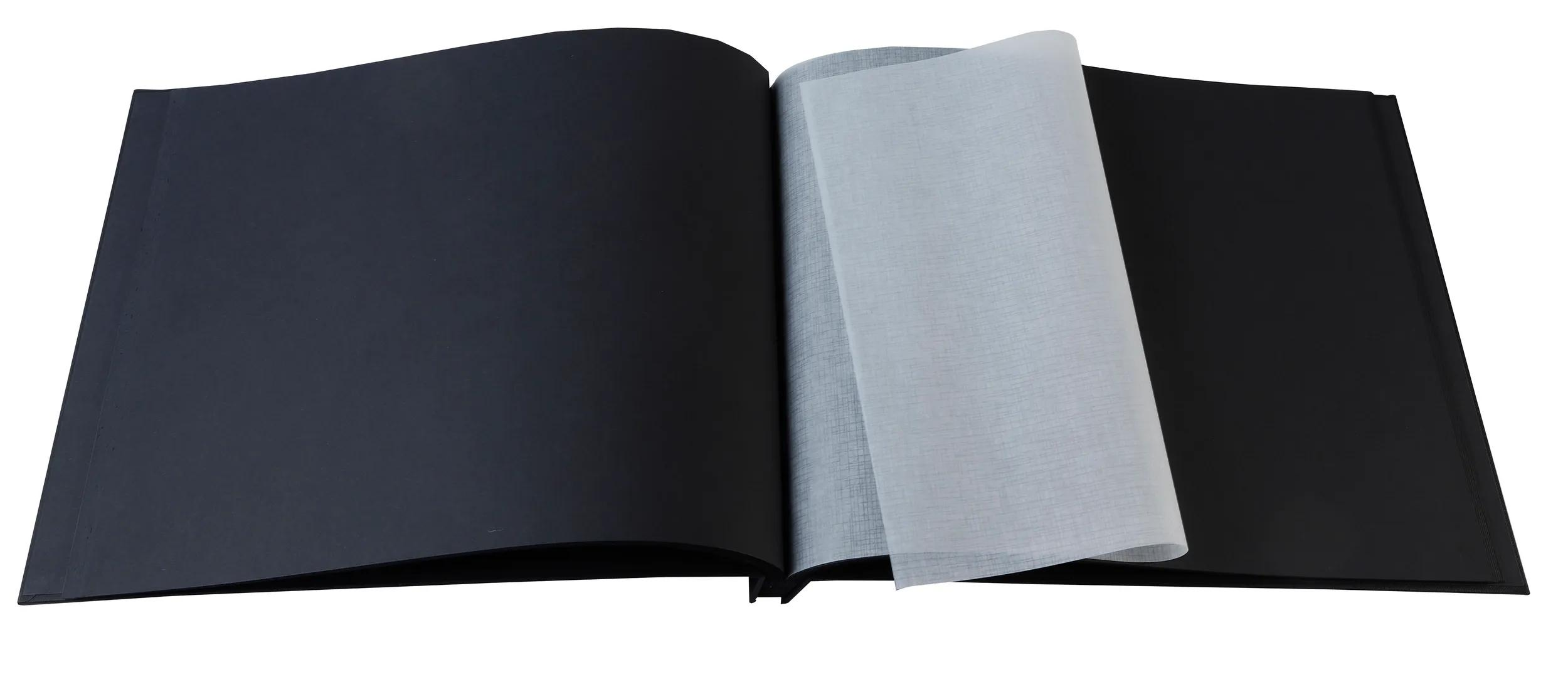 Un libro nero aperto con pagine nere e un foglio protettivo traslucido.
