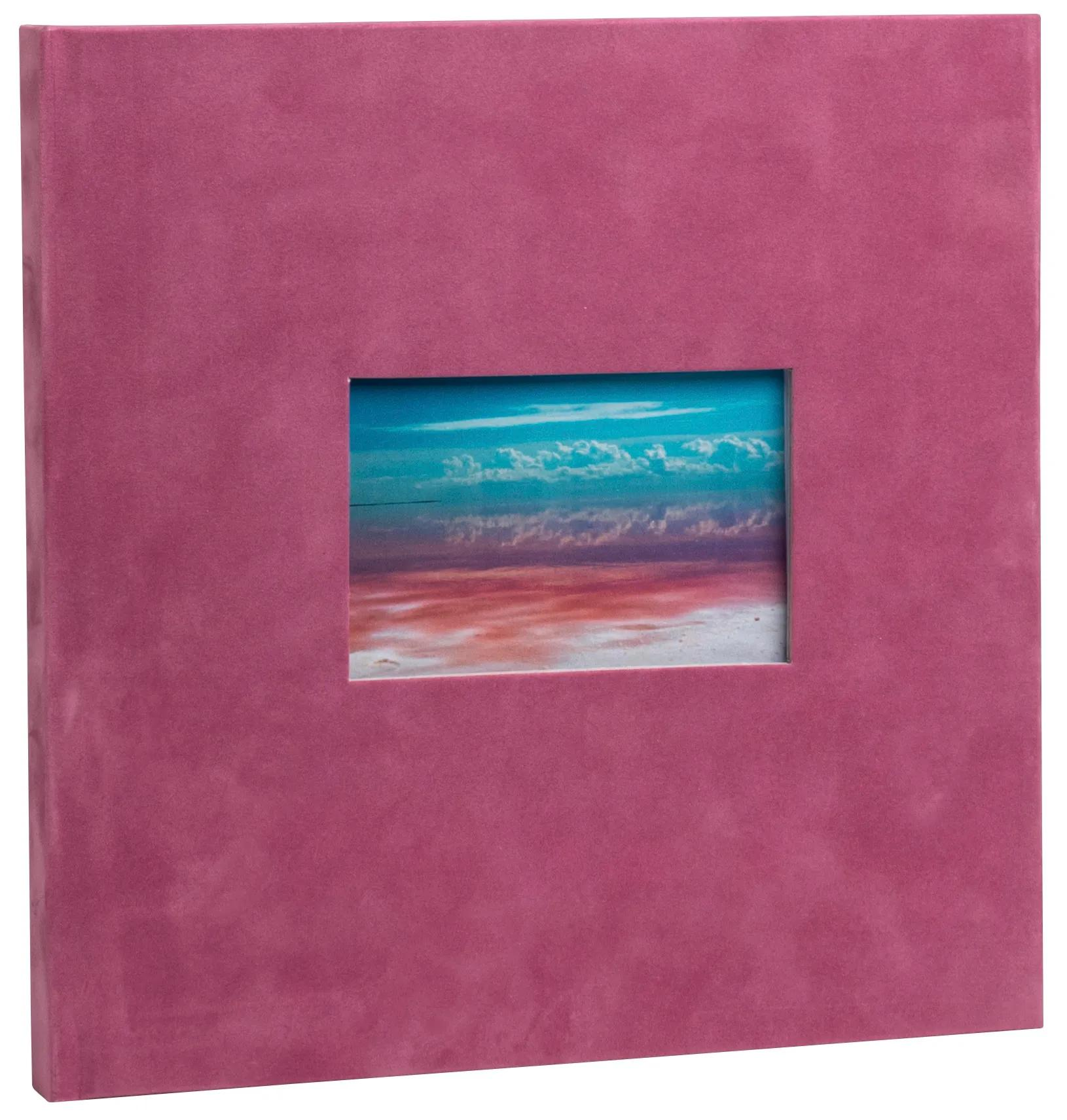 Un álbum rosa con un recorte que muestra un paisaje con cielo y agua.