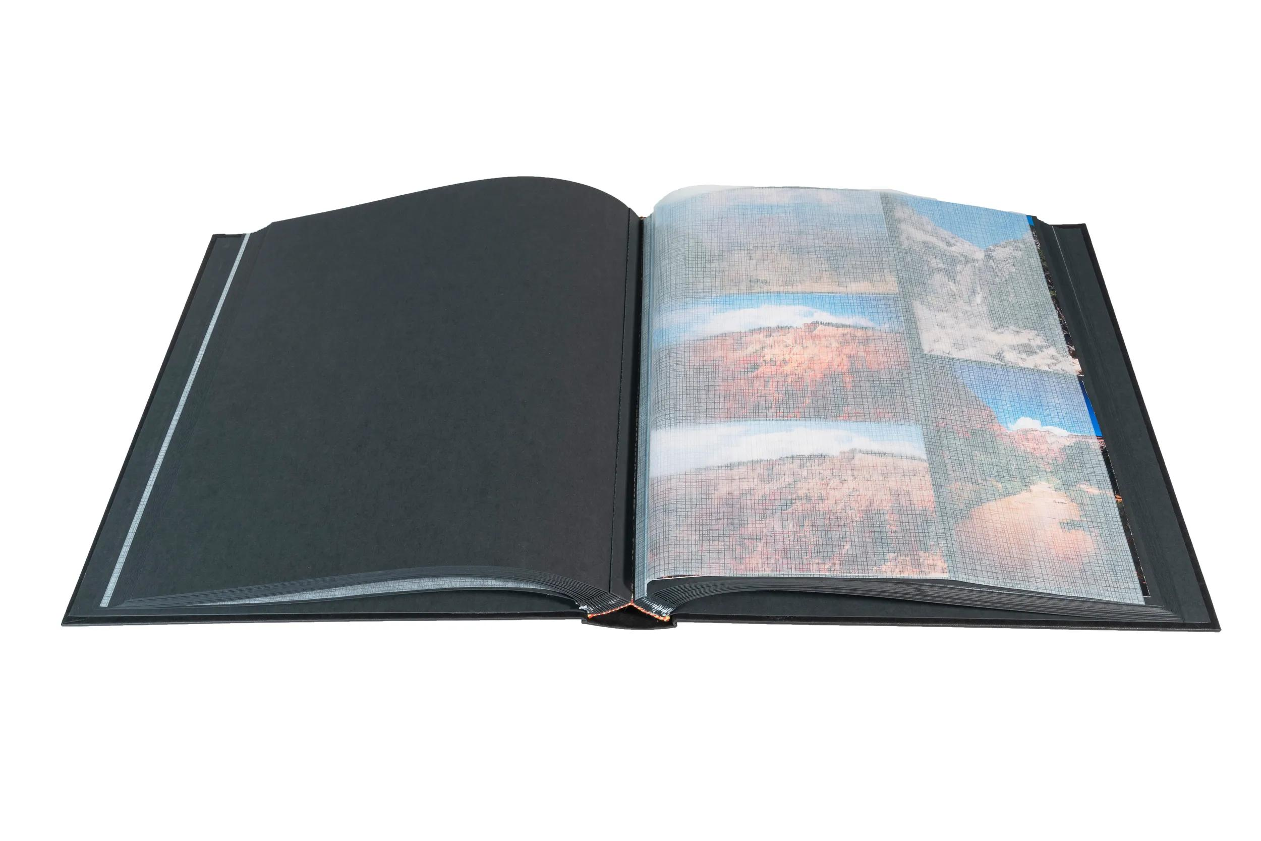 Un álbum de fotos abierto con páginas negras y fotos de paisajes en el lado derecho.