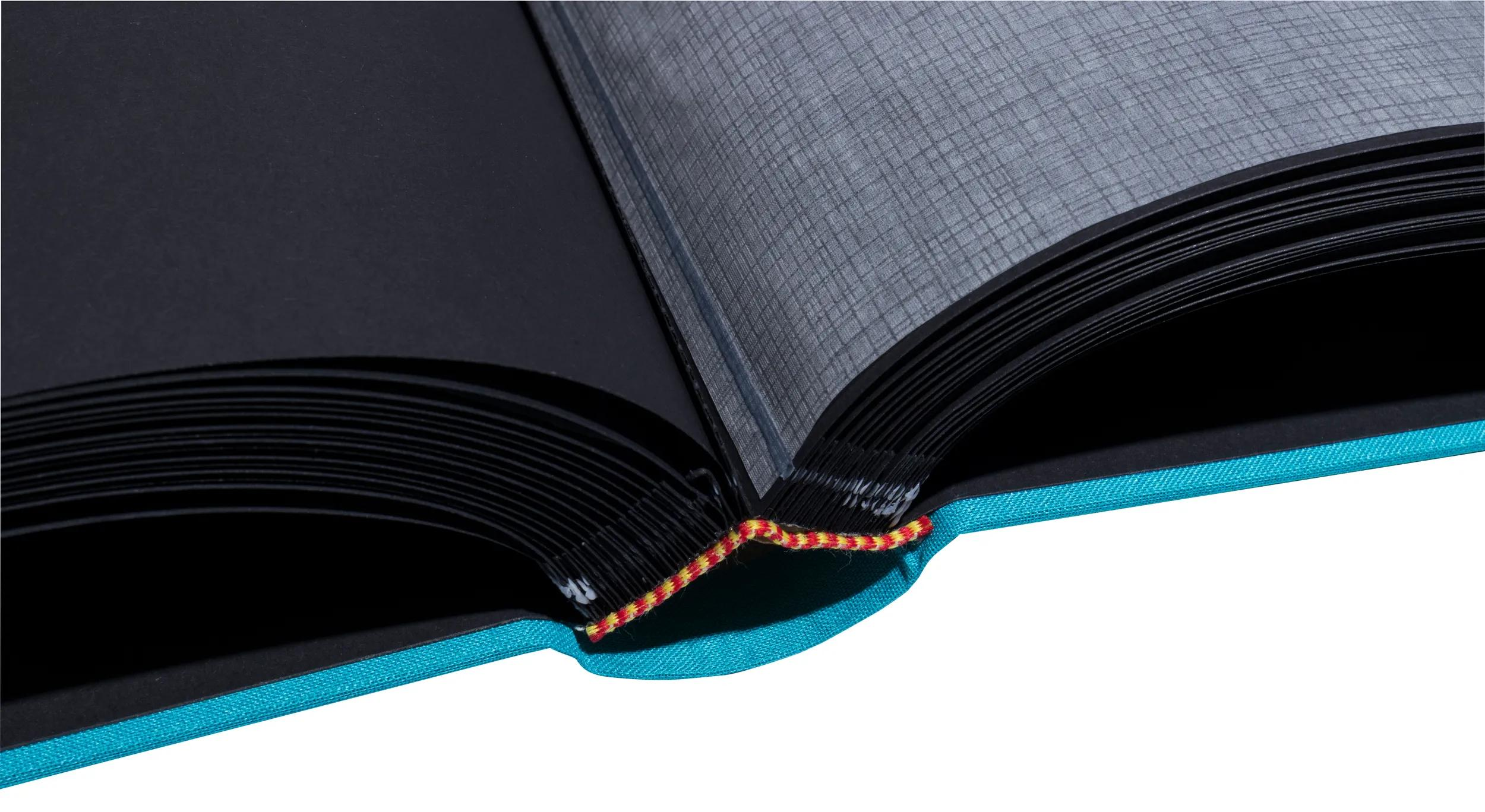 Álbum azul abierto con páginas negras y papel texturizado gris.