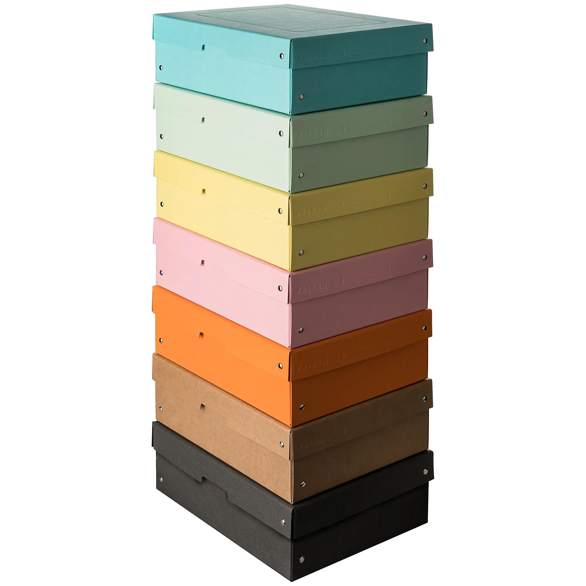 Una pila de cajas de almacenamiento coloridas en tonos pastel: verde azulado, verde claro, amarillo, rosa, naranja, marrón, gris oscuro.