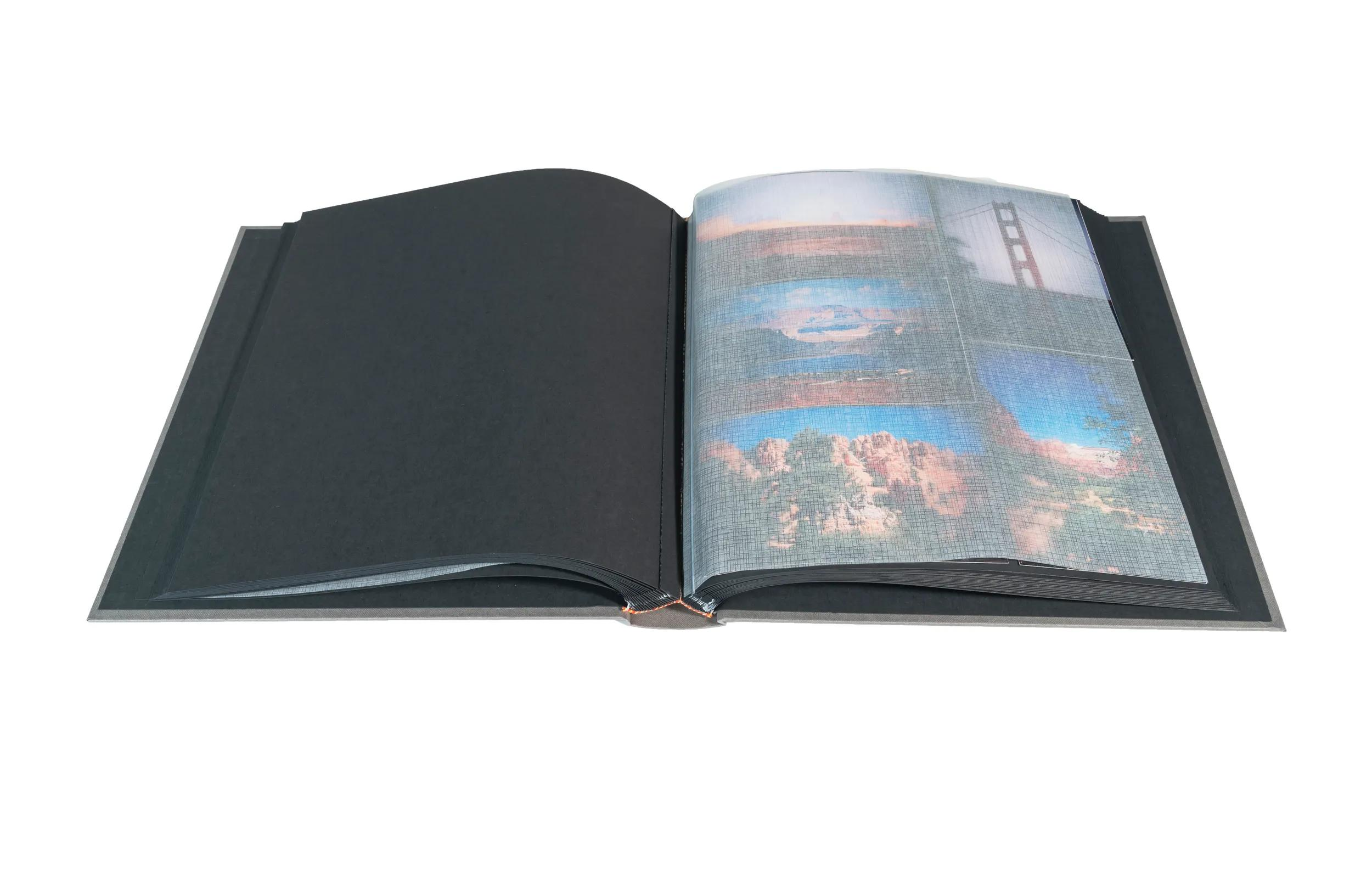 Un libro abierto con páginas negras y páginas que muestran fotos de paisajes.