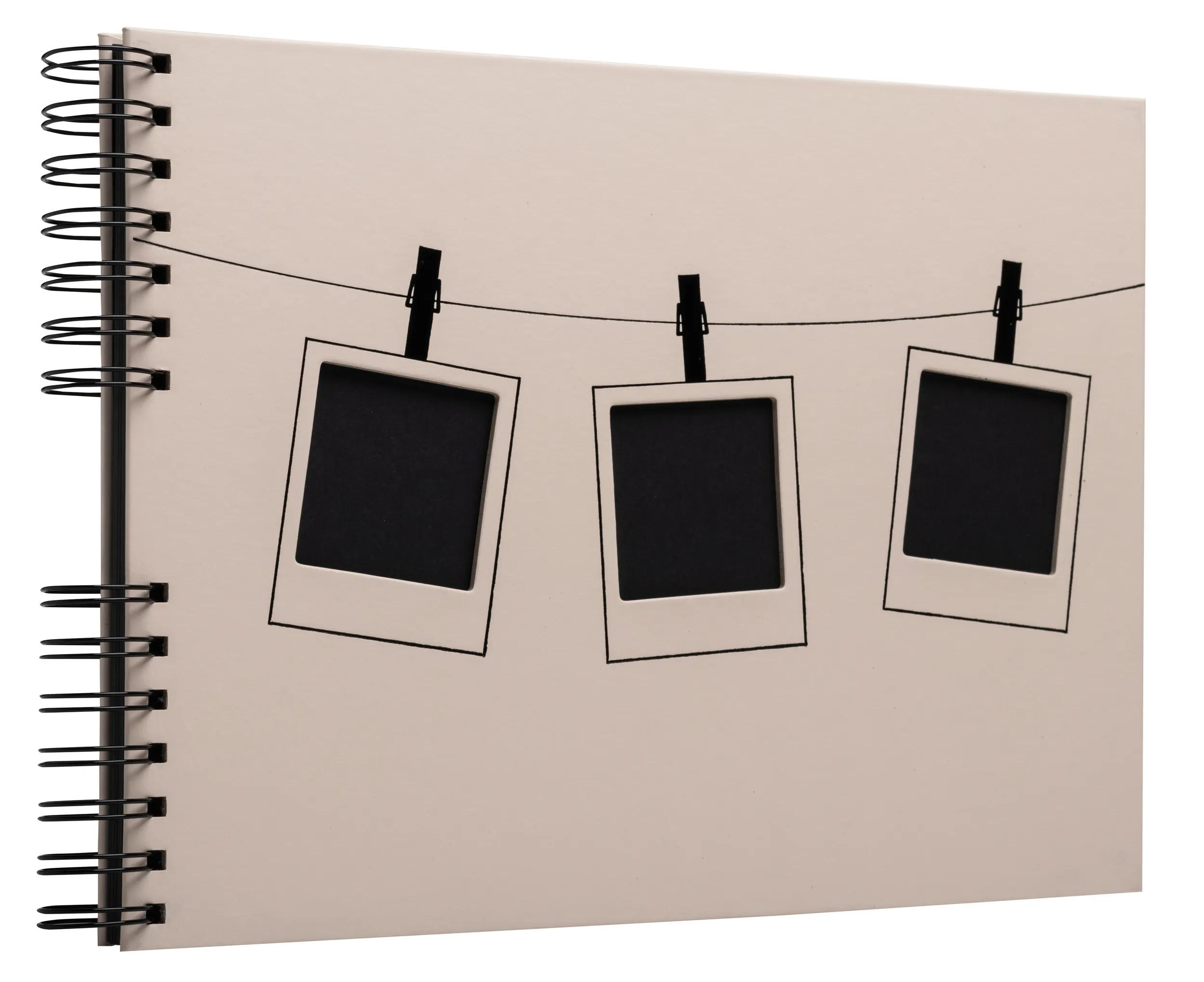 Un cuaderno con espiral que muestra tres marcos de fotos vacíos colgados de una cuerda.