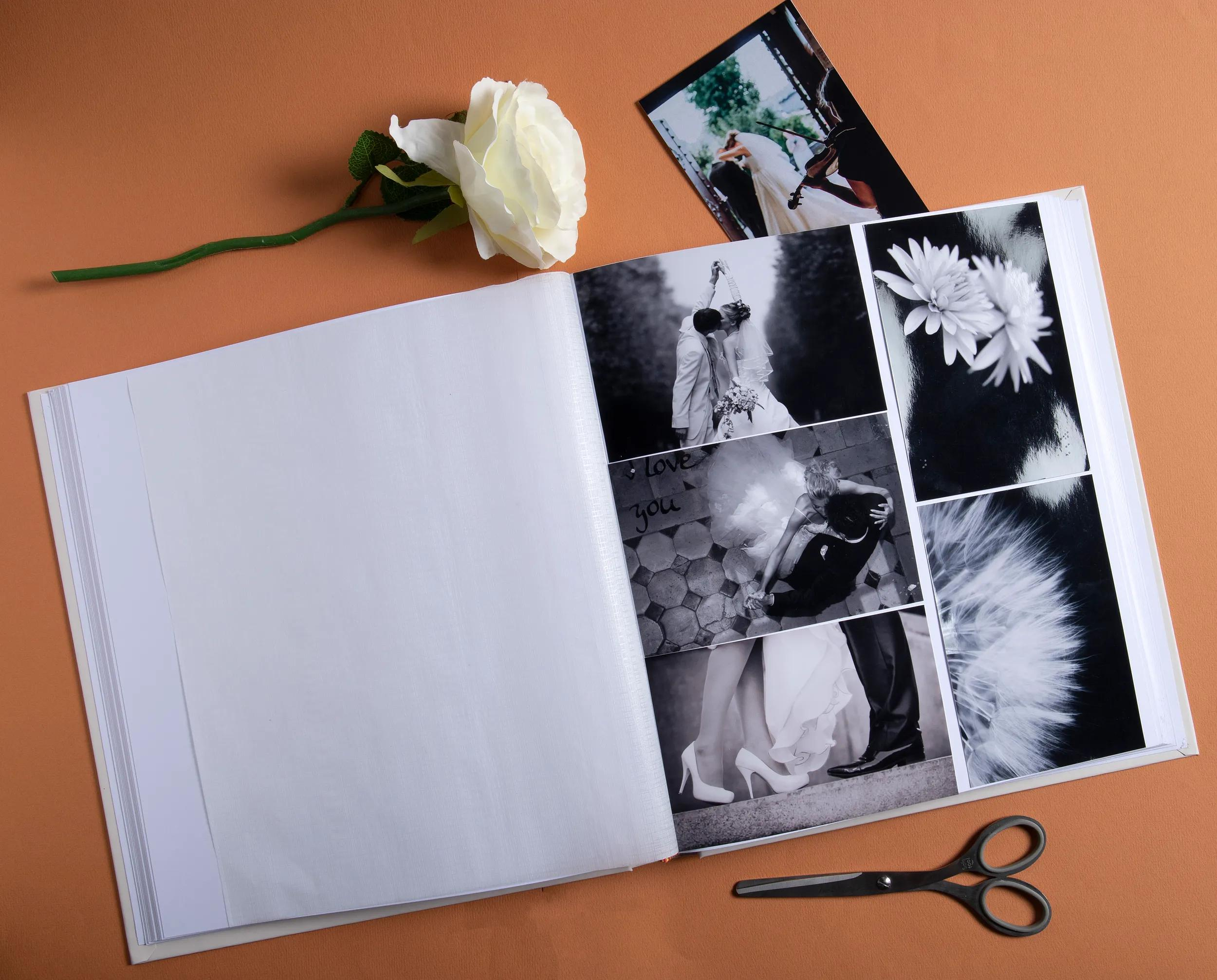 Un álbum de fotos abierto con fotos de bodas, una rosa blanca y tijeras.
