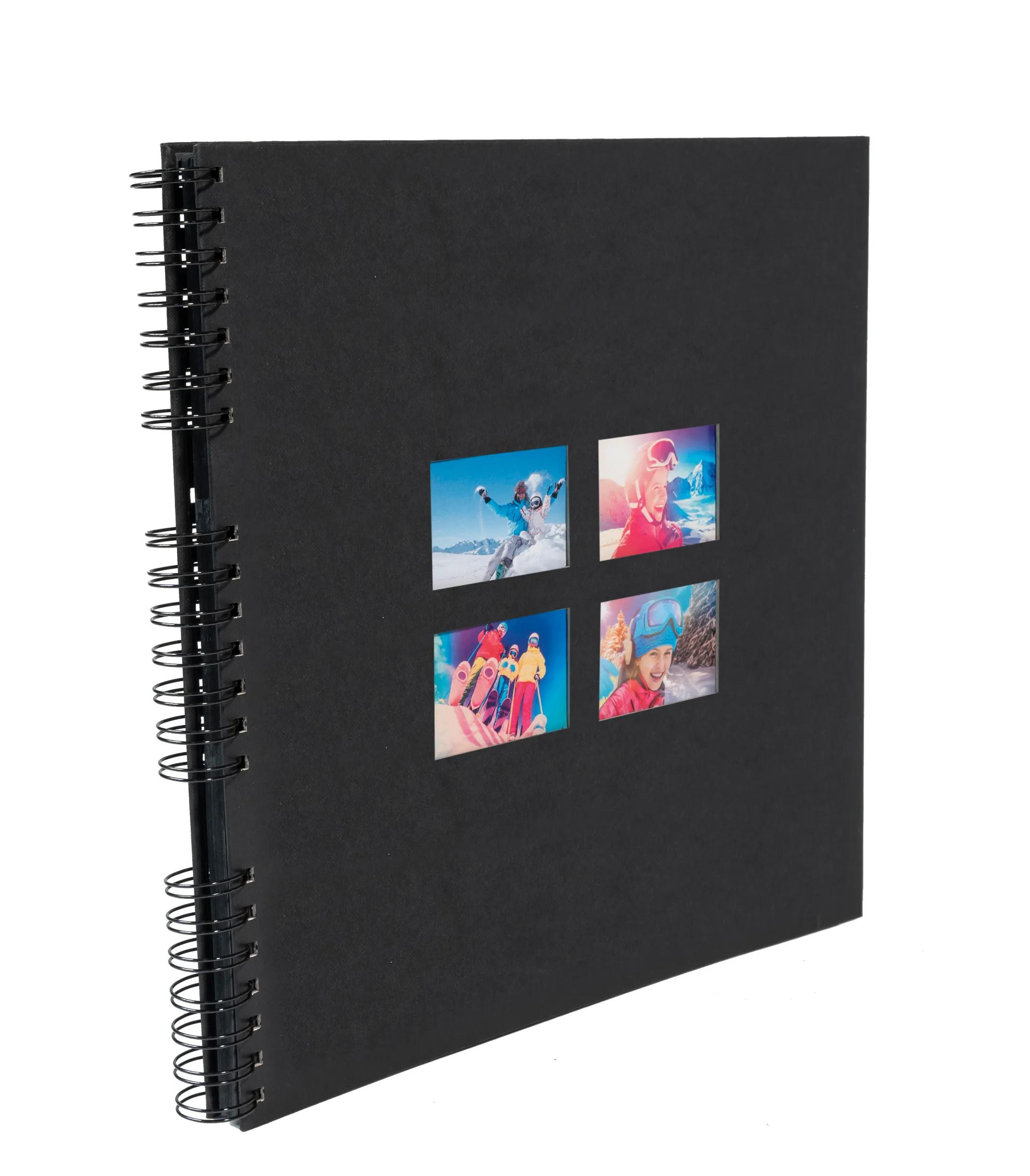 Un álbum negro de espiral con cuatro fotos pequeñas de esquiadores.