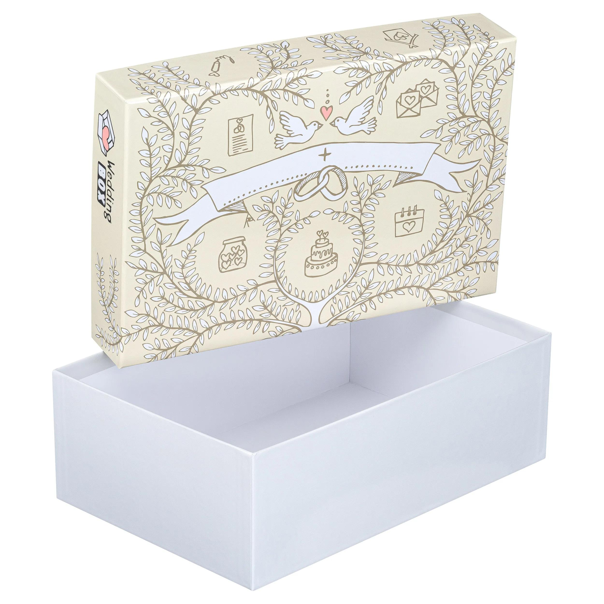 Una caja blanca abierta con tapa decorada con motivos de boda.