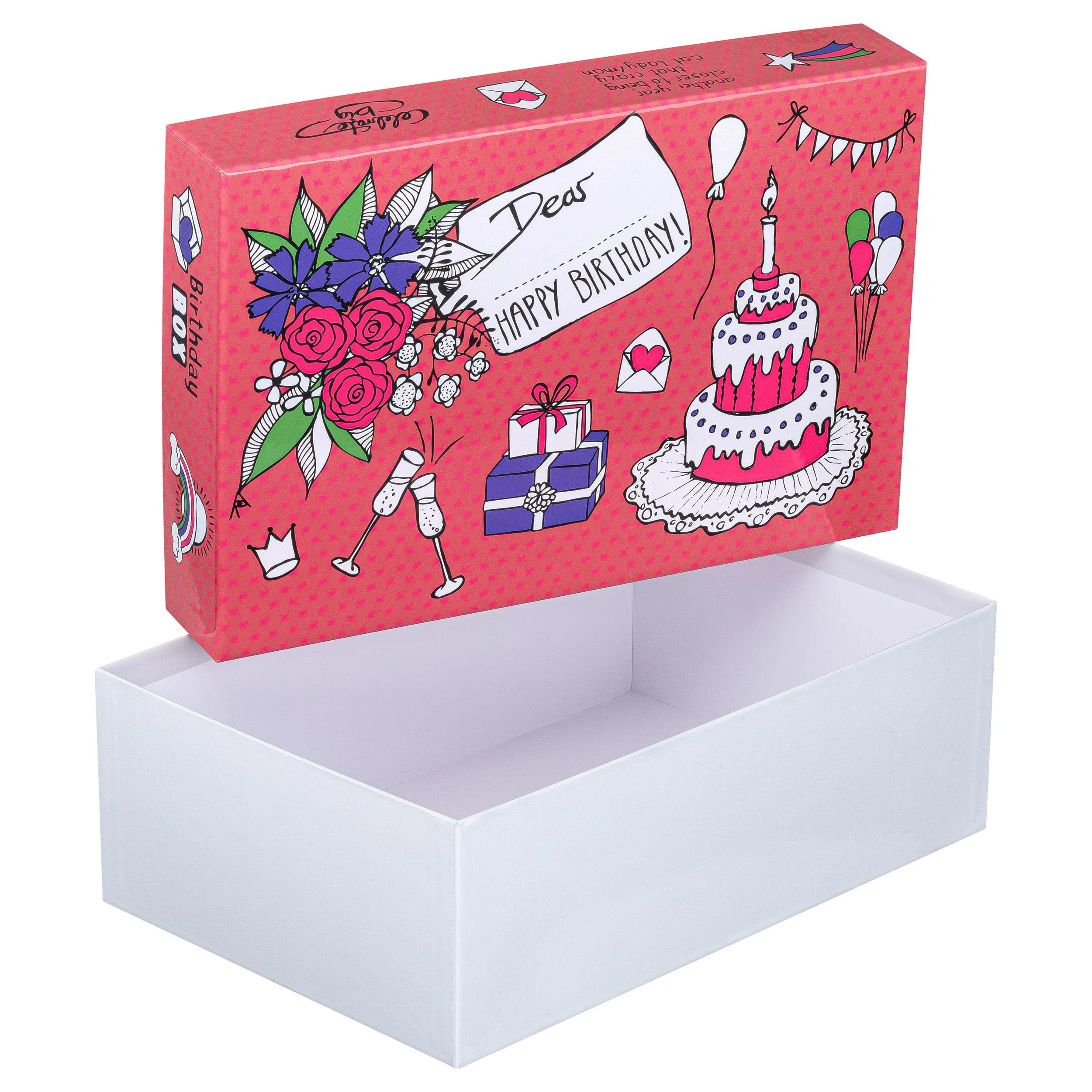 Una caja de cumpleaños con pastel, regalos y flores.