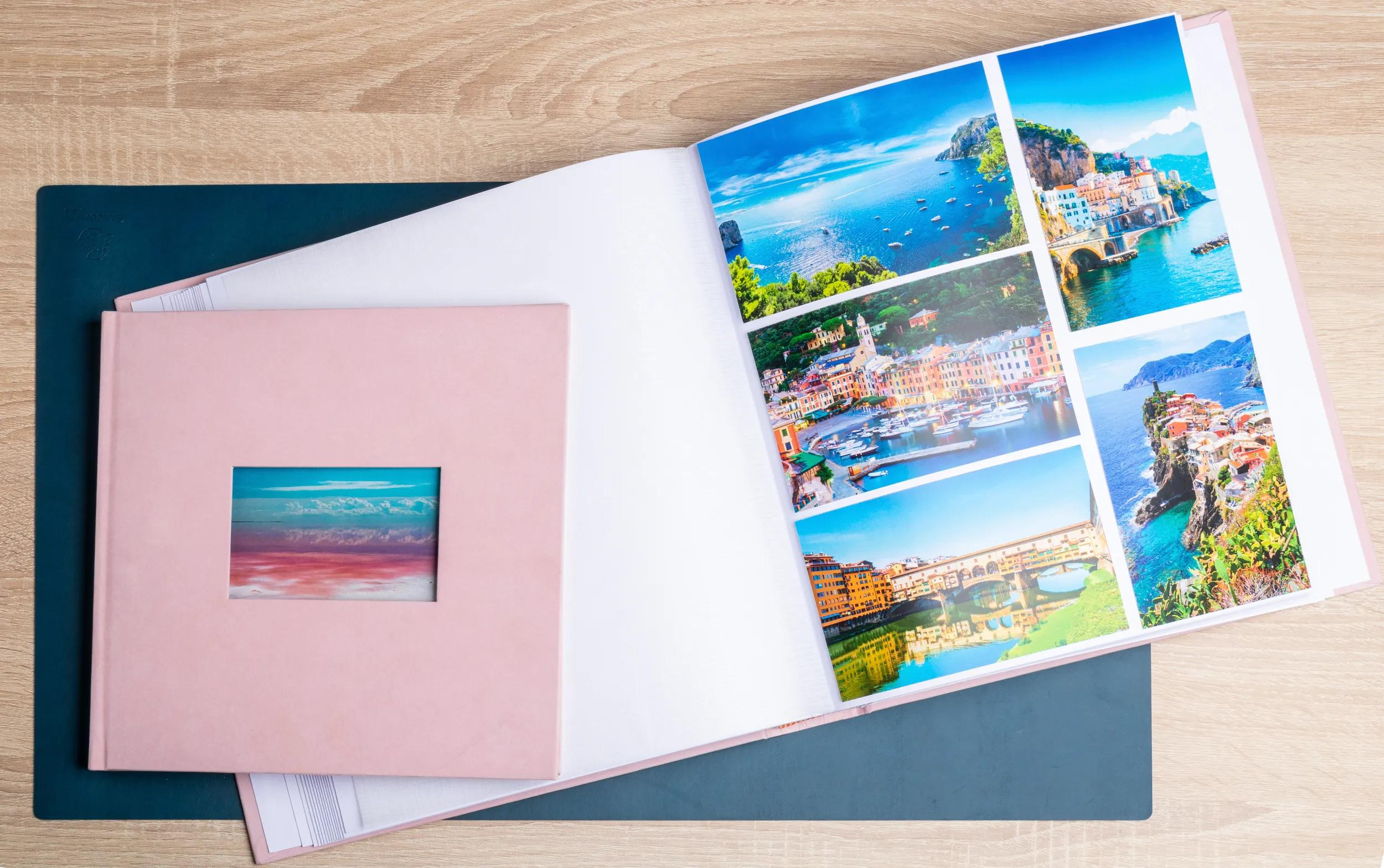 Un álbum de fotos abierto con imágenes de pueblos costeros y una cubierta rosa.