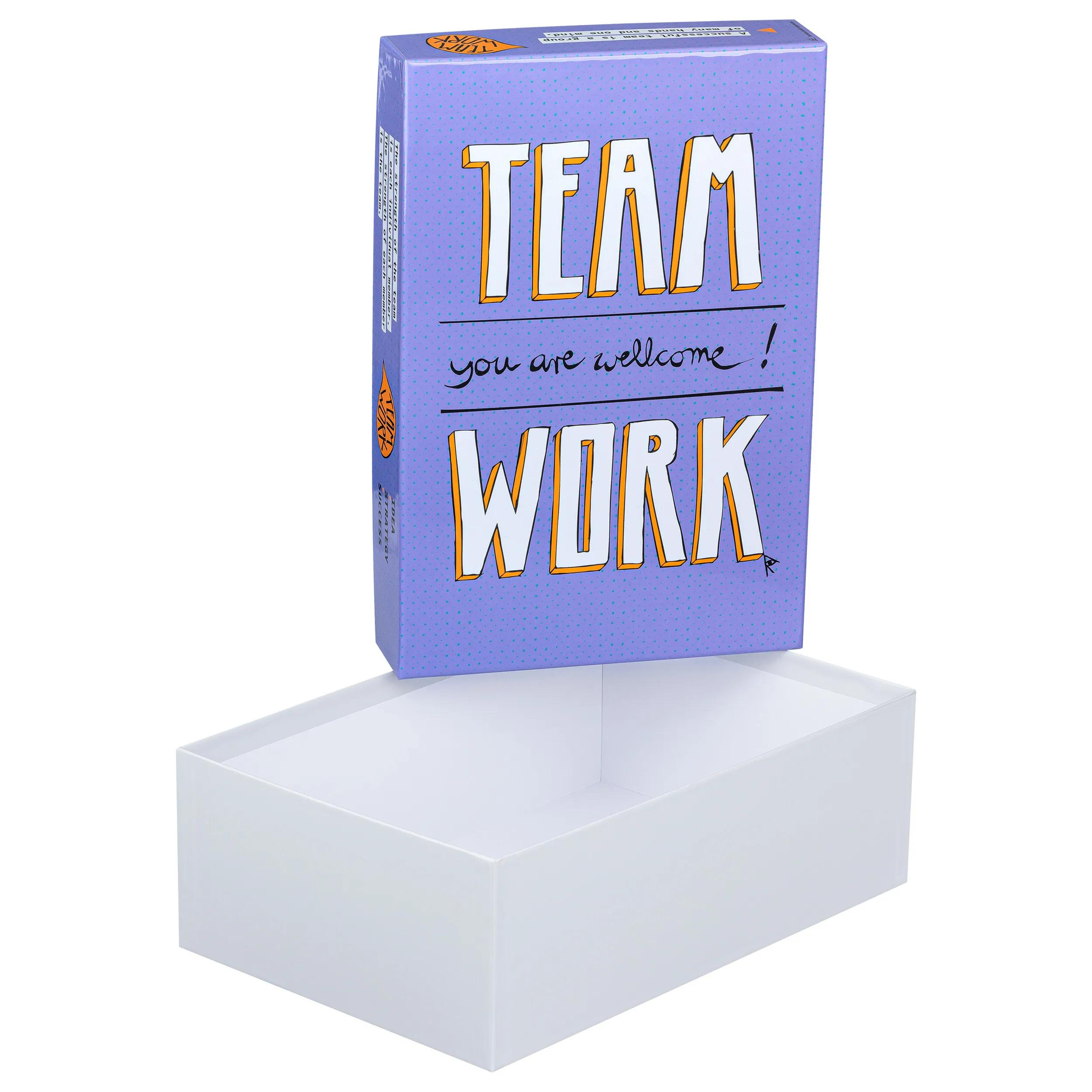 Una caja morada con el texto TEAM WORK sobre una caja blanca abierta.
