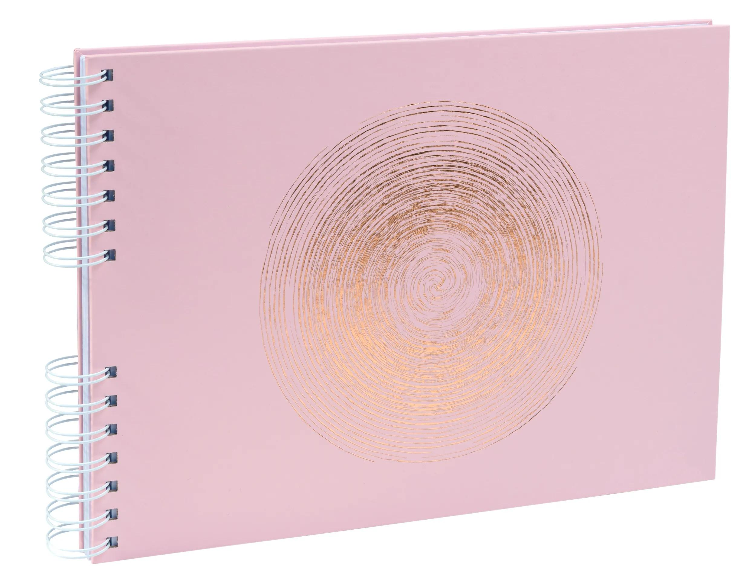 Un cuaderno rosa con un diseño de espiral dorada en la portada.
