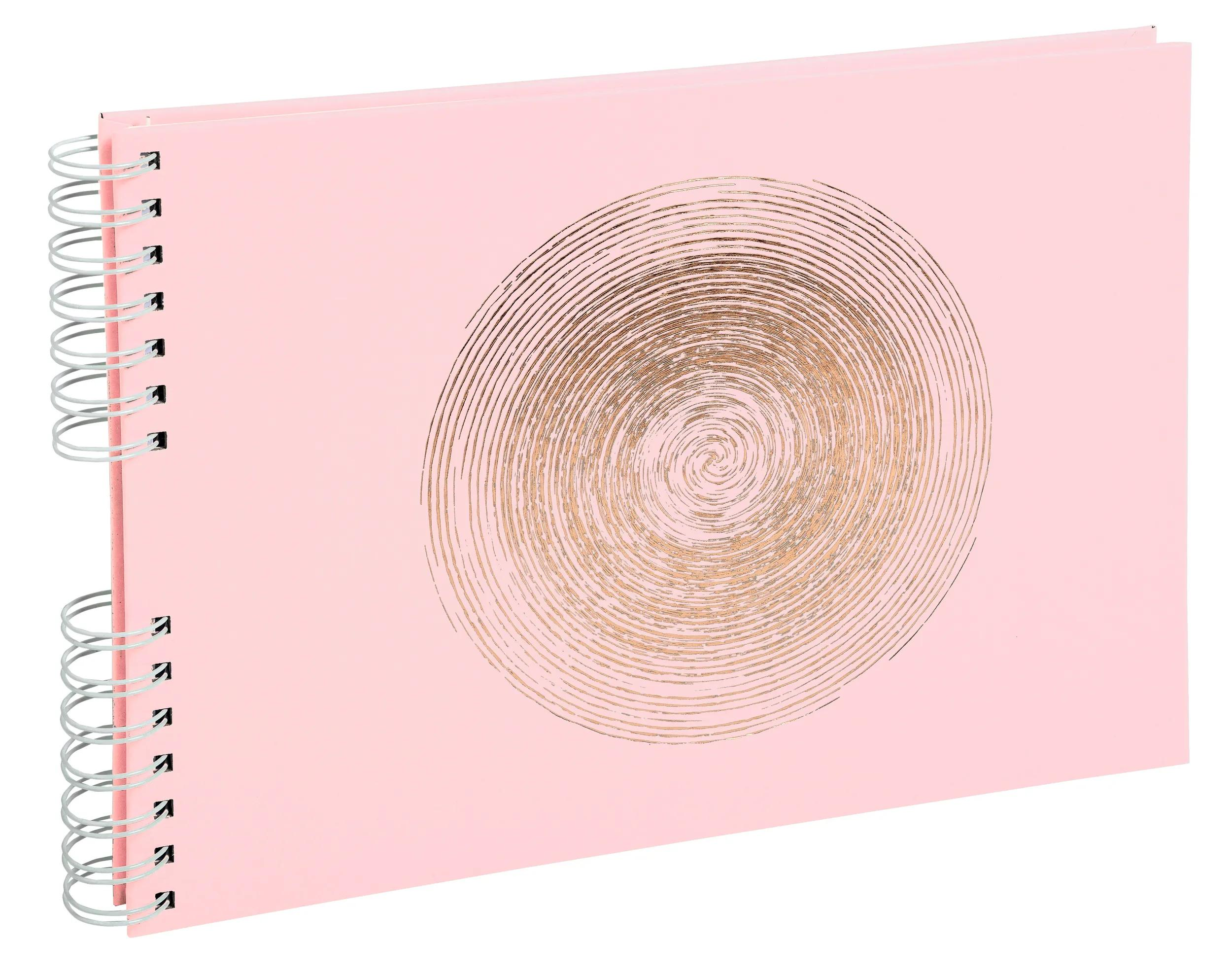Un cuaderno rosa con espiral y un diseño de remolino dorado en la portada.