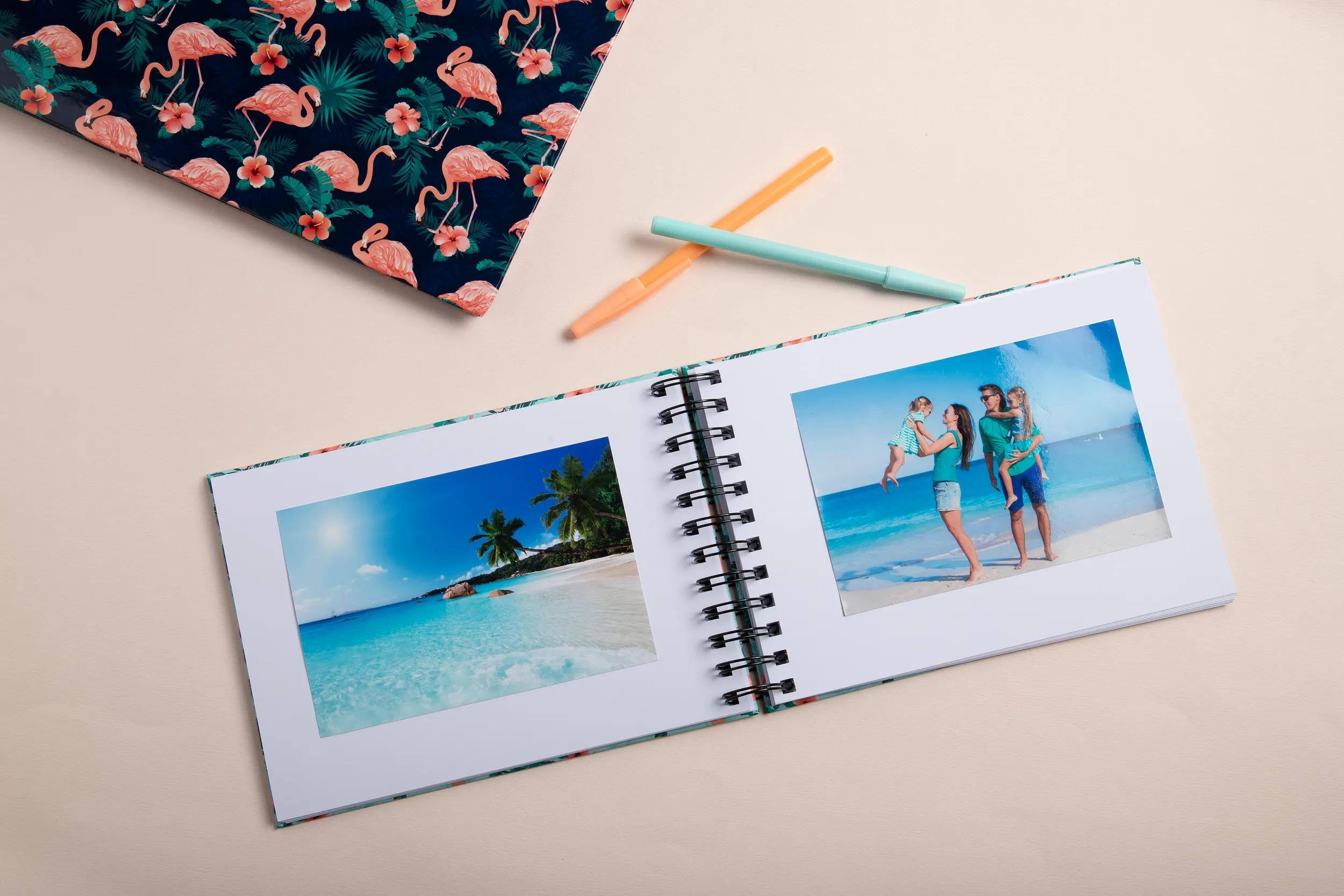 Un álbum de fotos abierto con fotos de playa y familiares yace sobre un fondo claro.