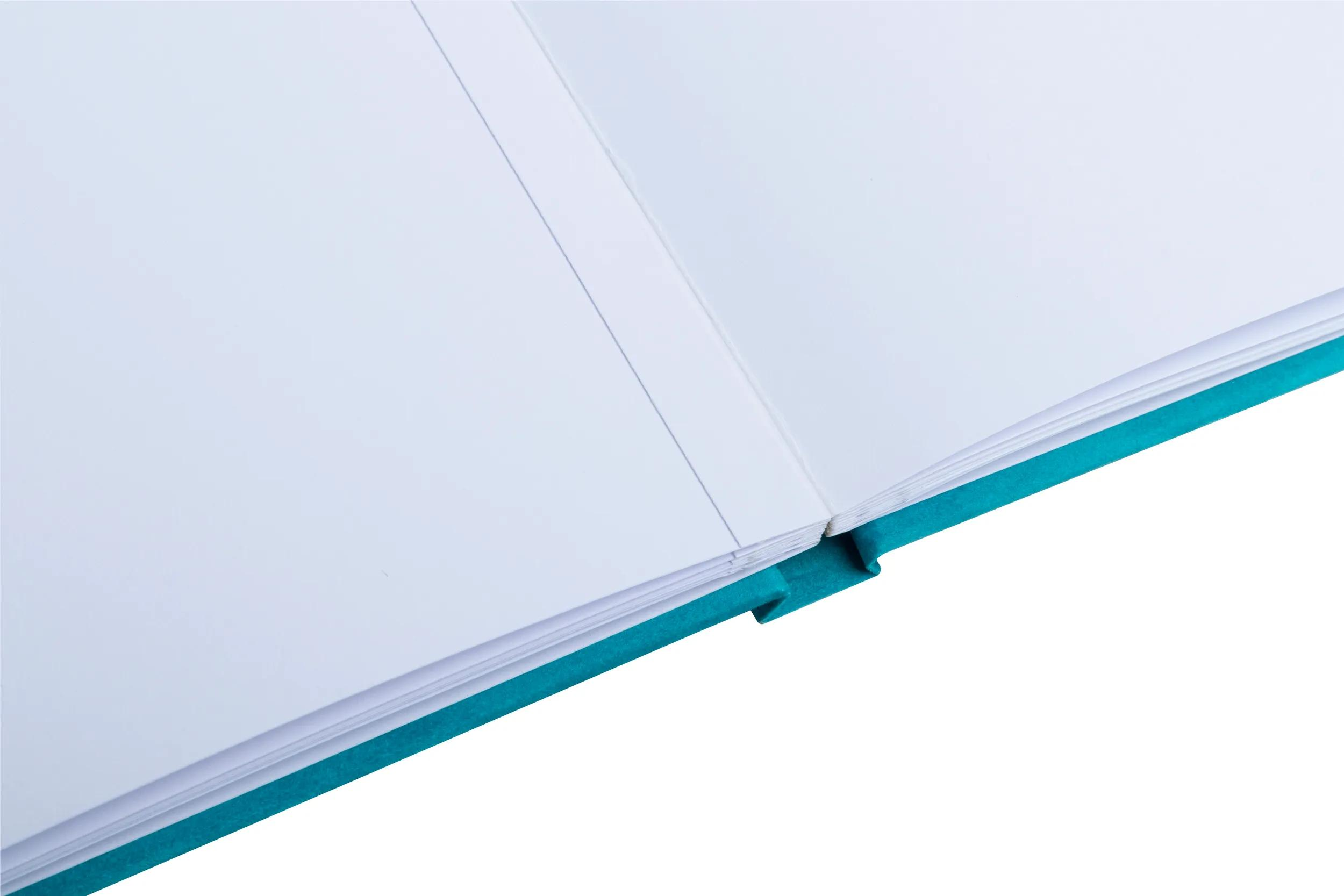 Un cuaderno abierto con cubierta turquesa y páginas blancas.