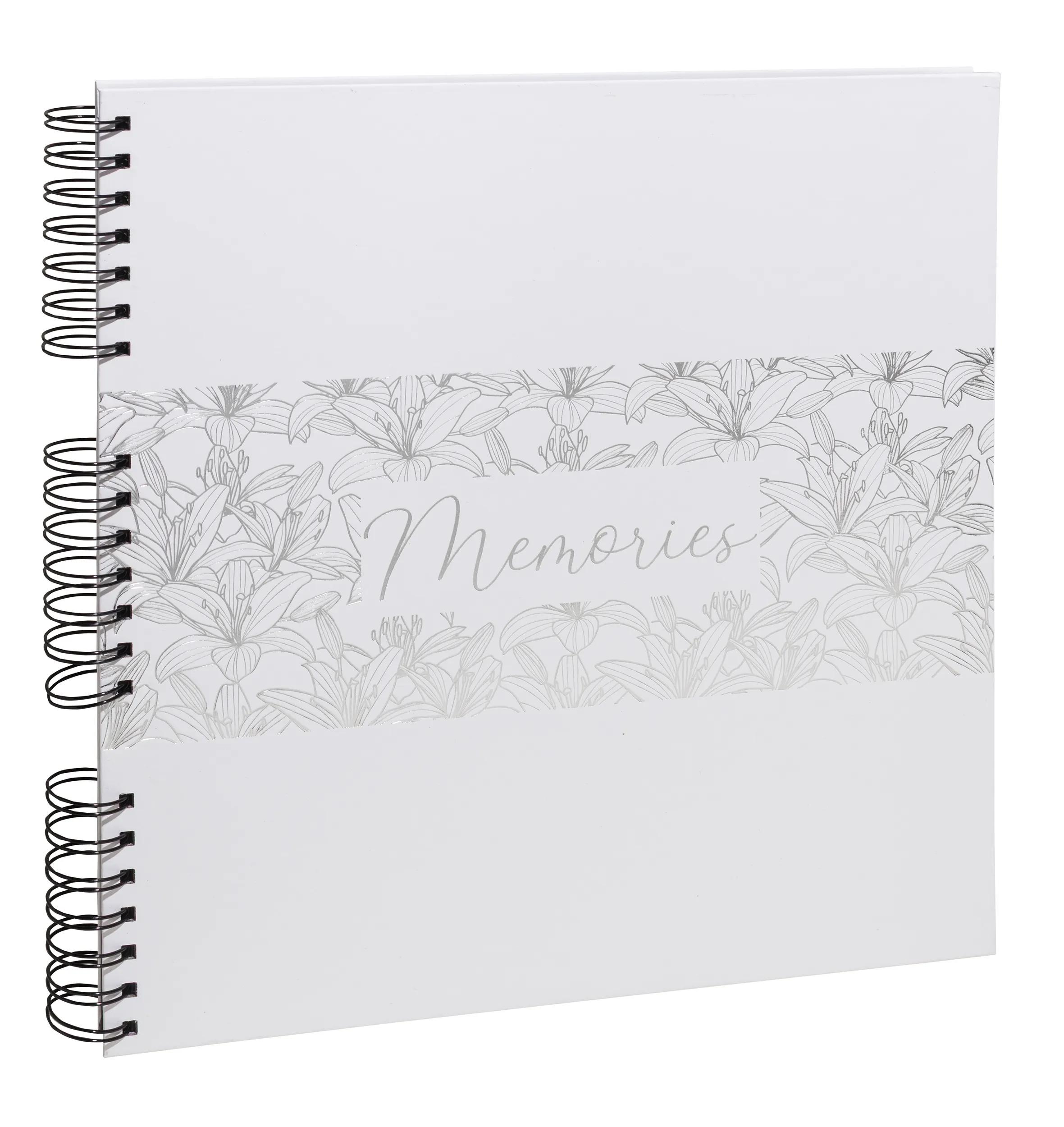 Un cuaderno blanco con lirios plateados y la palabra "Memories".