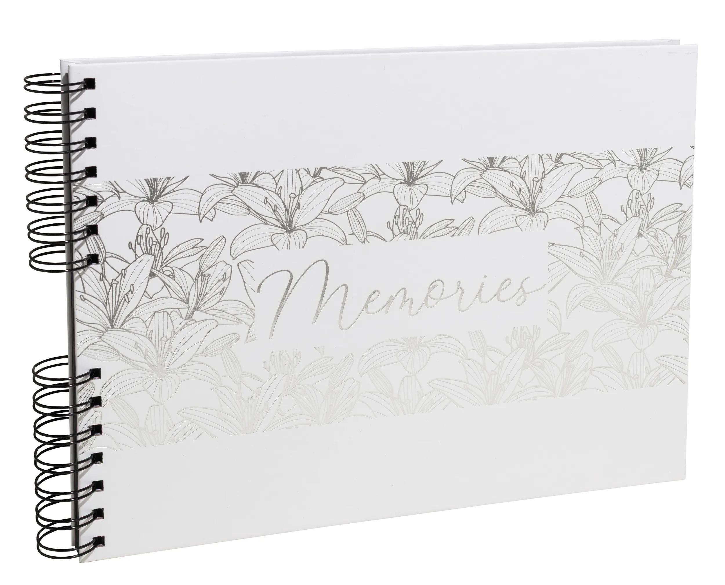 Un álbum de recortes blanco con lirios plateados y la palabra "Memories".