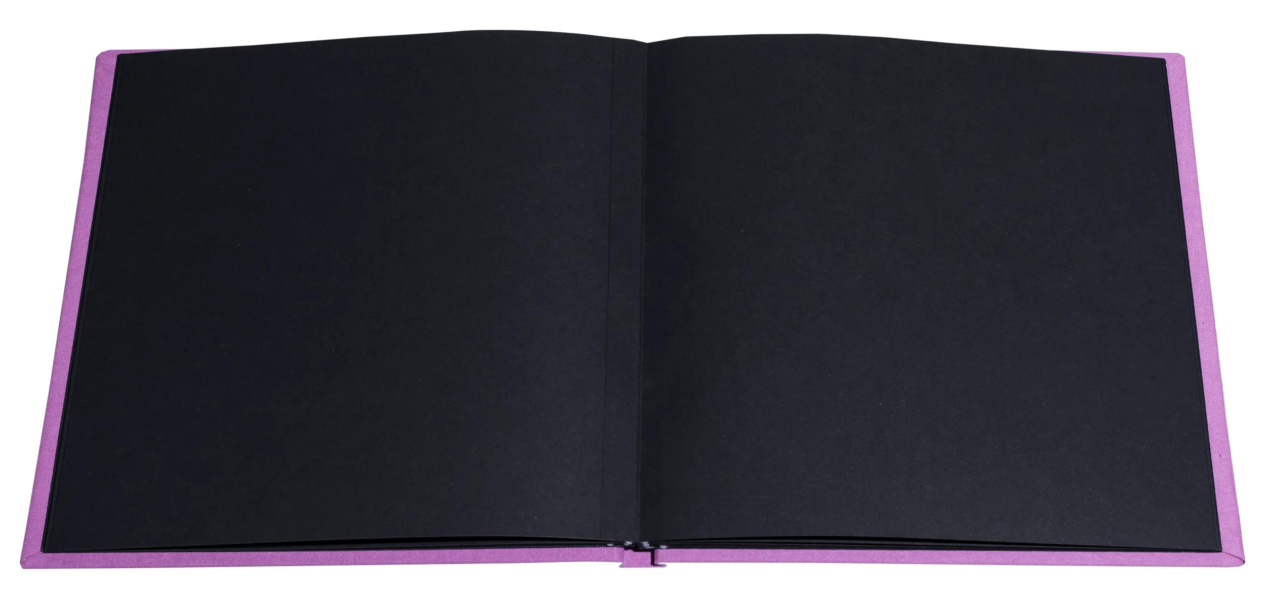Un cuaderno morado abierto con páginas negras.
