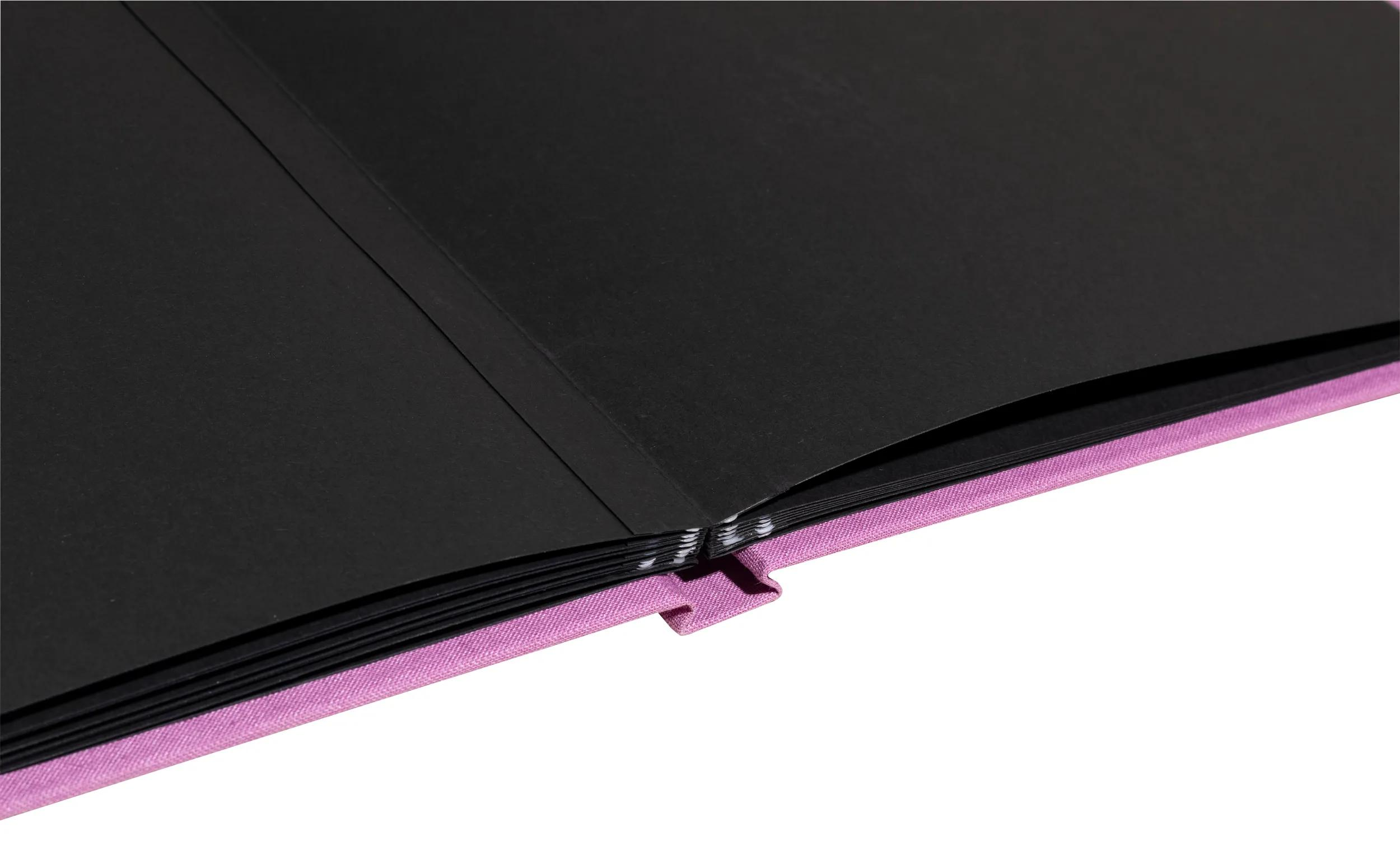 Un libro morado abierto con páginas negras, sobre fondo blanco.